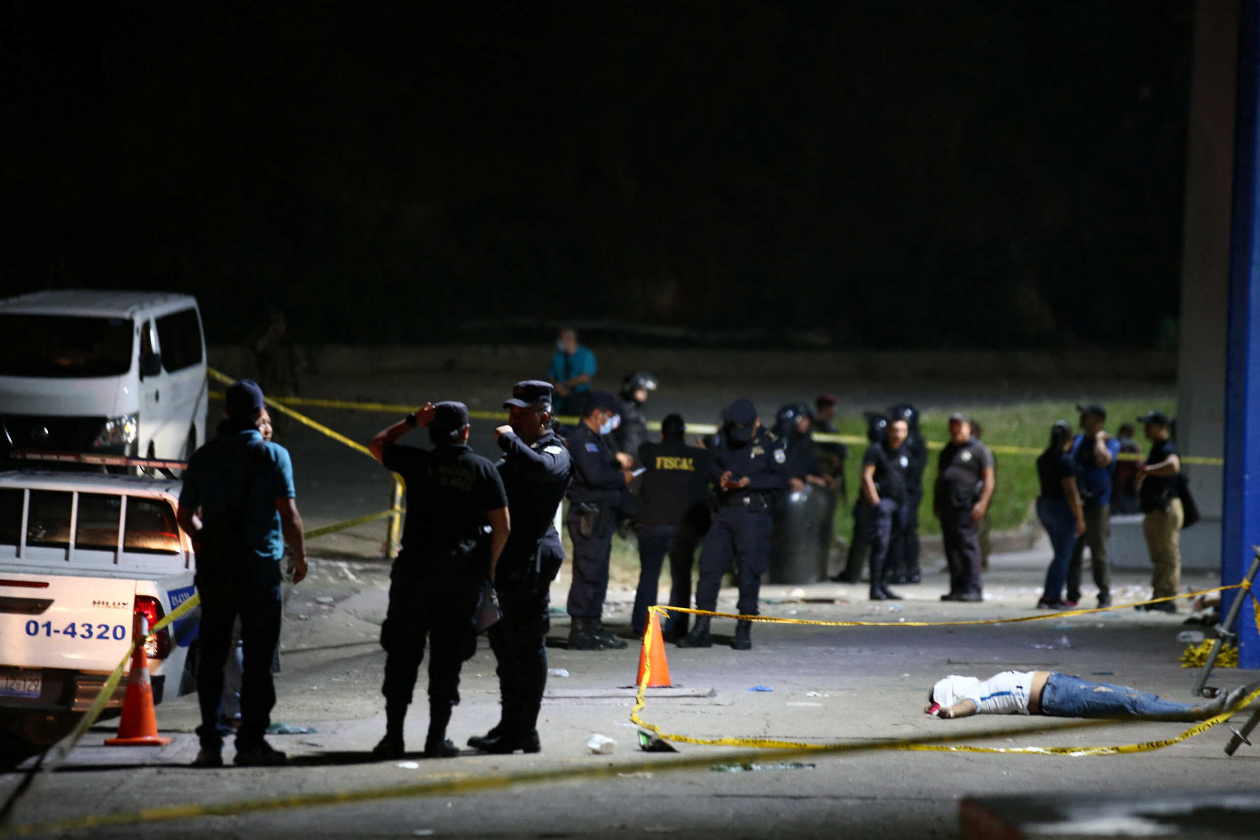SENSITIVE MATERIAL. THIS IMAGE MAY OFFEND OR DISTURB Policemen stand near the body of a fan who was killed in a stampede prior to a soccer game between C.D. FAS Vs. Alianza F.C. at the Cuzcatlan stadium, in San Salvador, El Salvador May 20, 2023. REUTERS