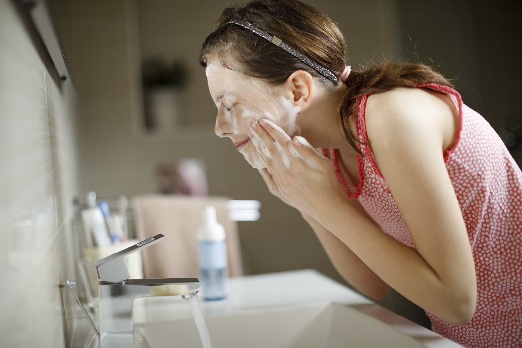 Teenage girl washing her face