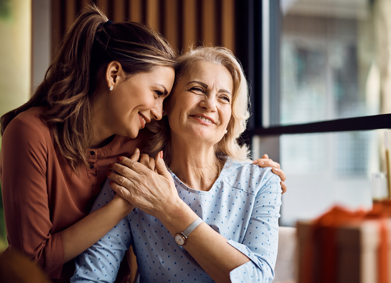 Happy senior woman enjoying in daughter's affection on Mother's day.