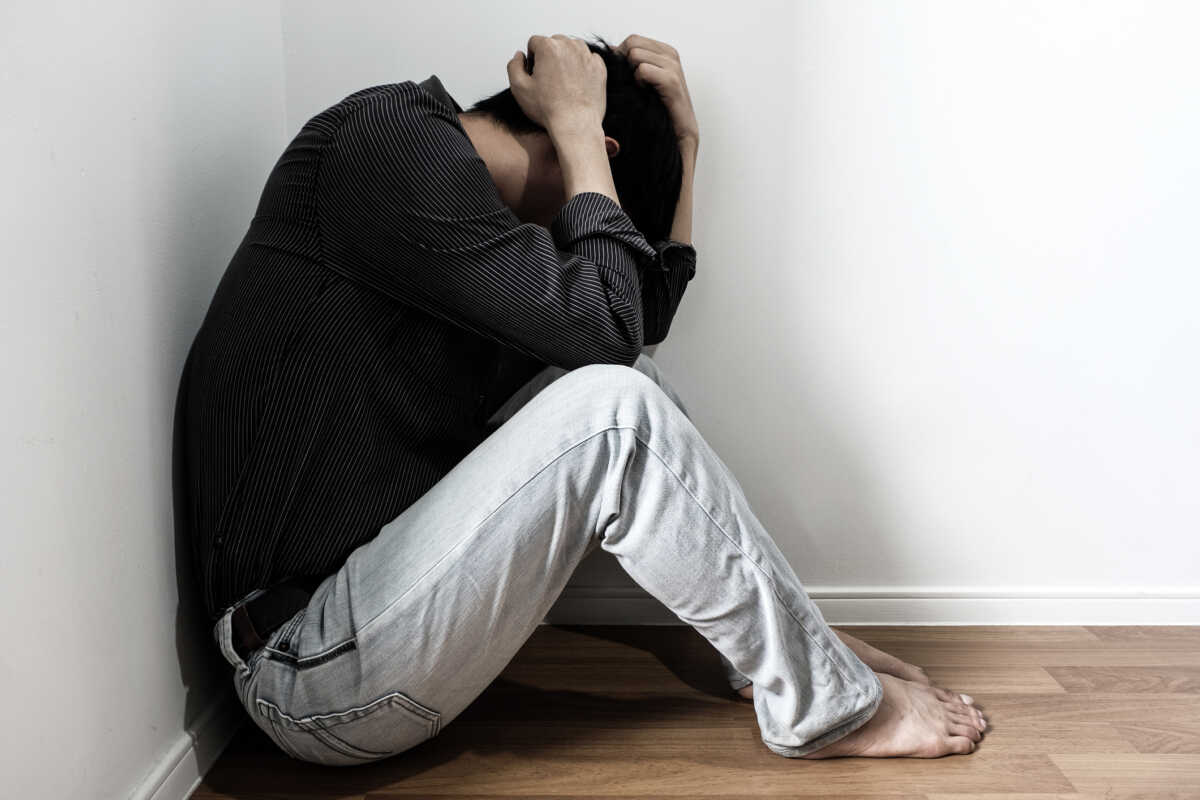man sitting in the corner of the room have emotional and mental problems He has depression and stress from society and work. medical concept