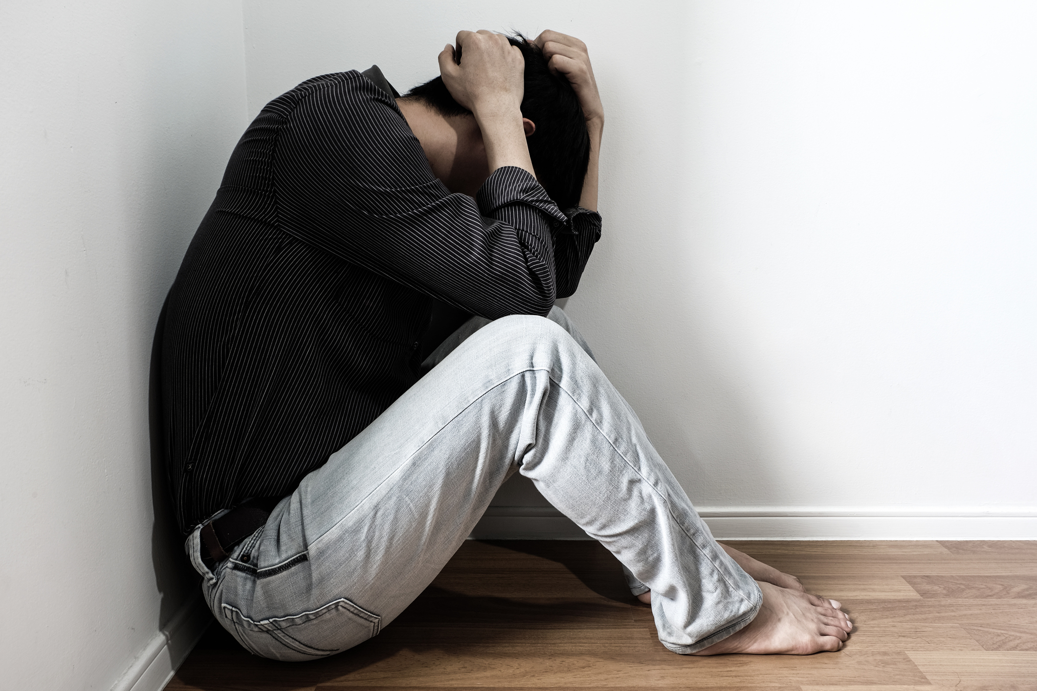 man sitting in the corner of the room have emotional and mental problems He has depression and stress from society and work. medical concept