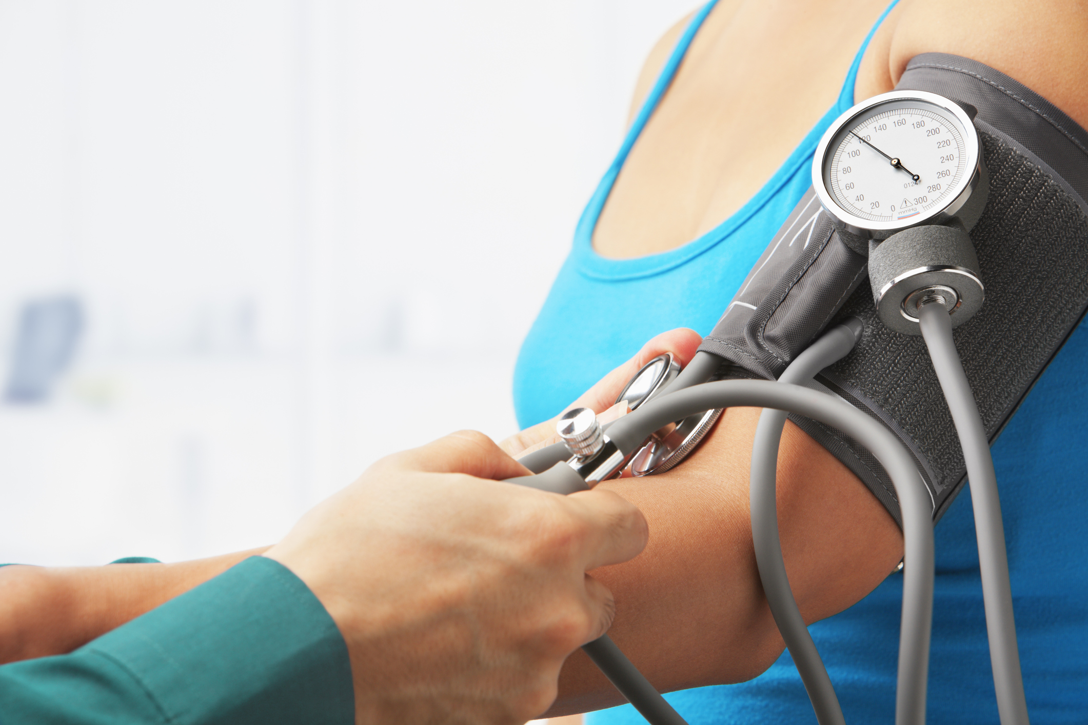 Checking blood pressure of female patient, unrecognizable people