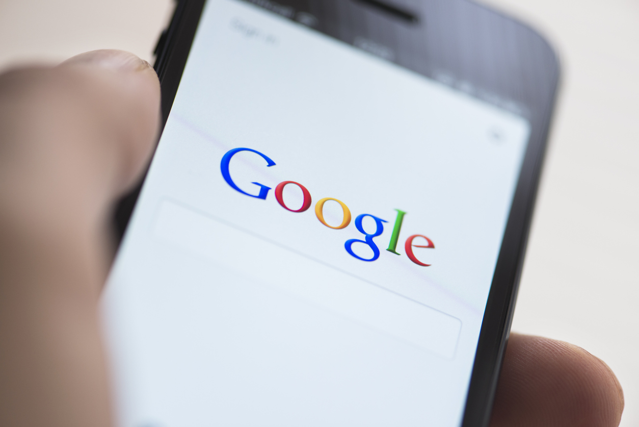 "istanbul, Turkey - February 4, 2013: Woman hand holding and touching Apple iPhone 5. iPhone 5 displaying log in screen of Google application. The iPhone 5 is smartphone with multi touch screen produced by Apple Computer, Inc. Google Inc. is an American multinational corporation that provides Internet-related products and services, including internet search, cloud computing, software and advertising technologies."