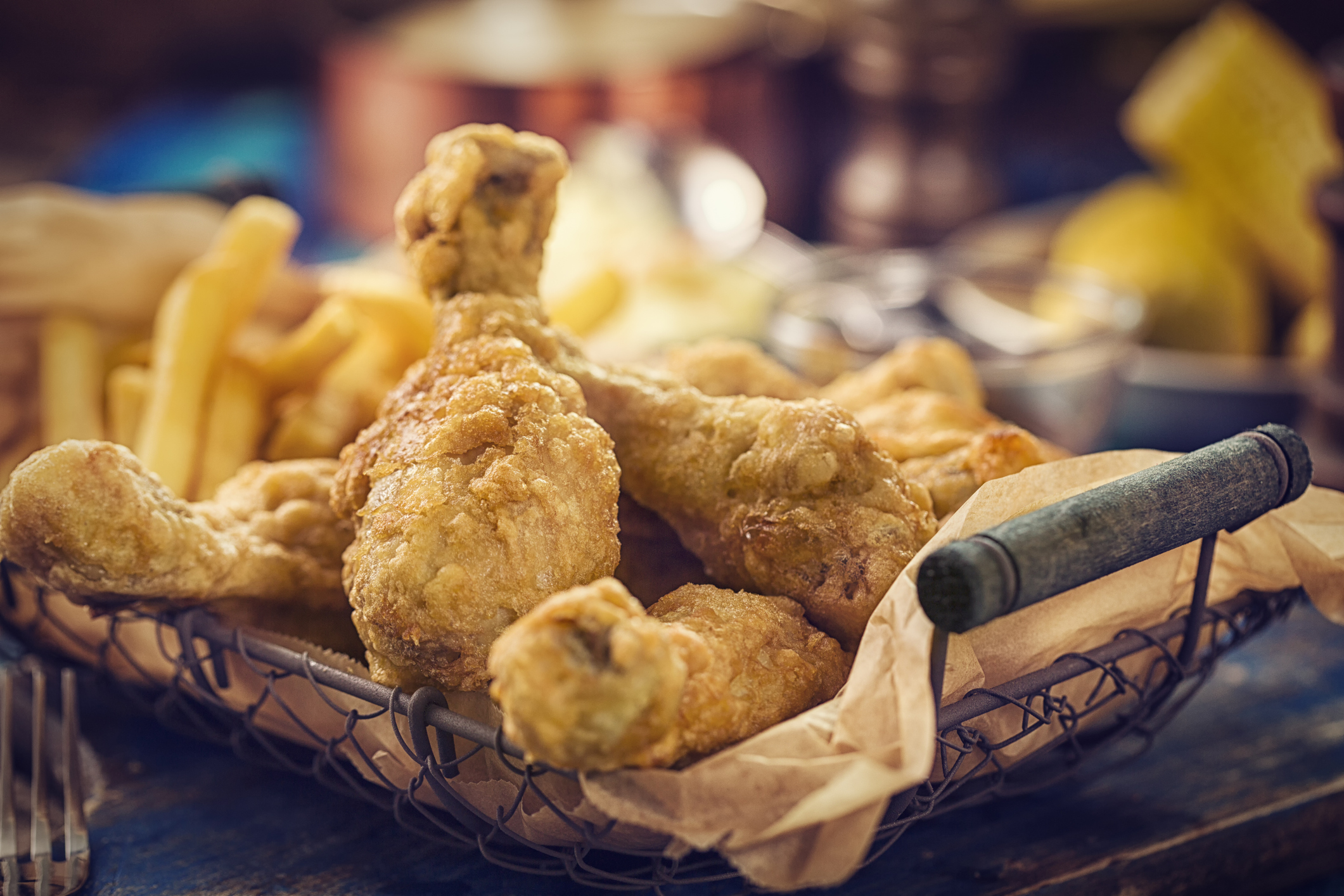 Homemade golden fried chicken legs served in a basket. Super crunchy and ready to eat.