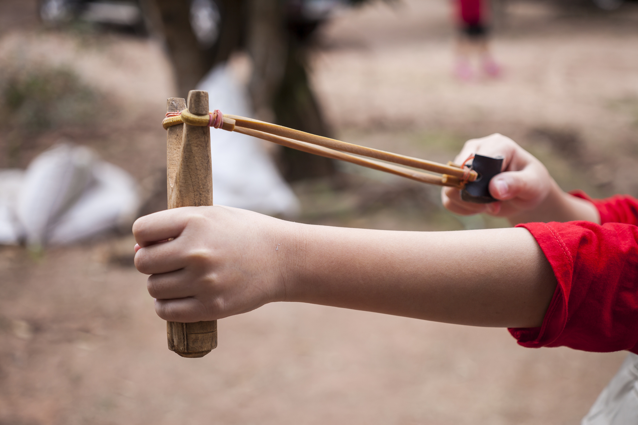Hand boy pulling sling shot.