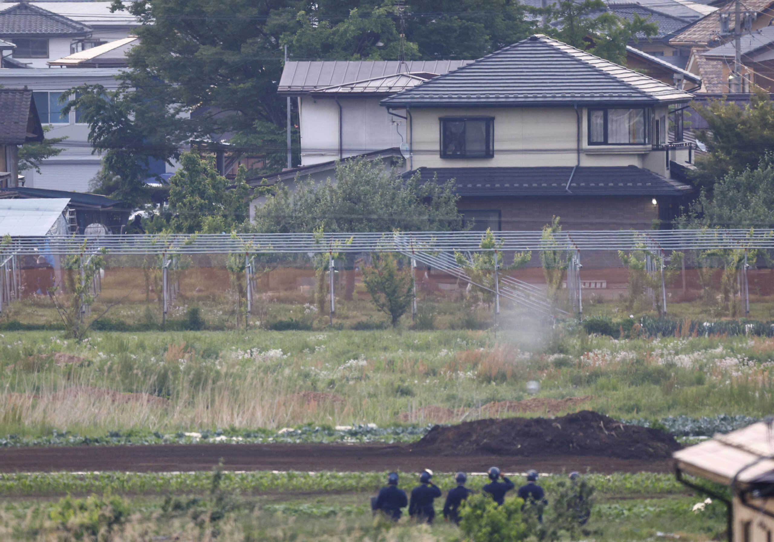 Police officers surround the scene of  a stabbing and shooting incident in Nakano, Nagano Prefecture, central Japan, in this photo taken by Kyodo on May 26, 2023. Picture taken with a telephoto lens through obstacles. Mandatory credit Kyodo