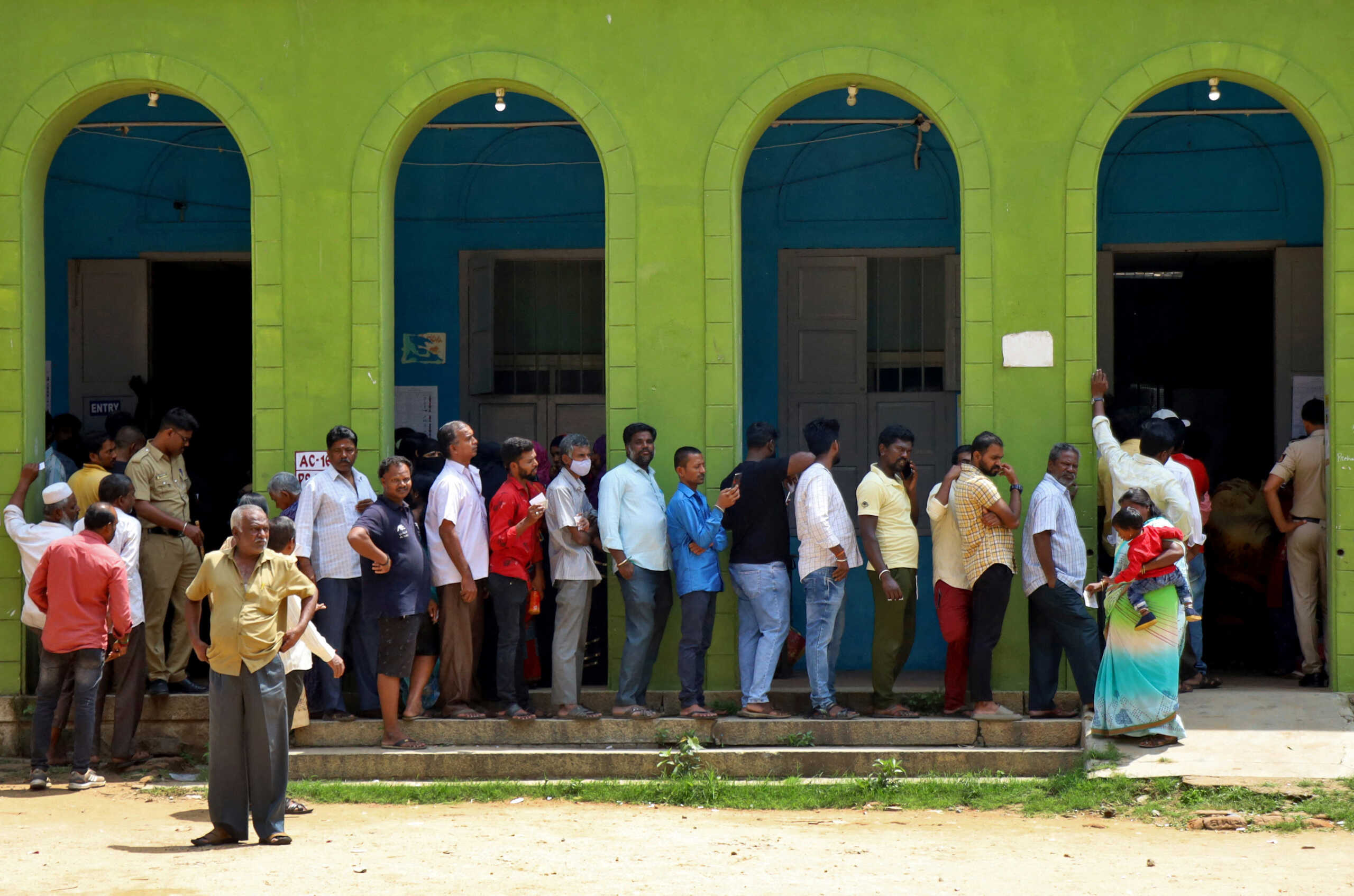People wait in a queue to cast their vote at a polling station during Karnataka state assembly election in Bengaluru, India, May 10, 2023. REUTERS