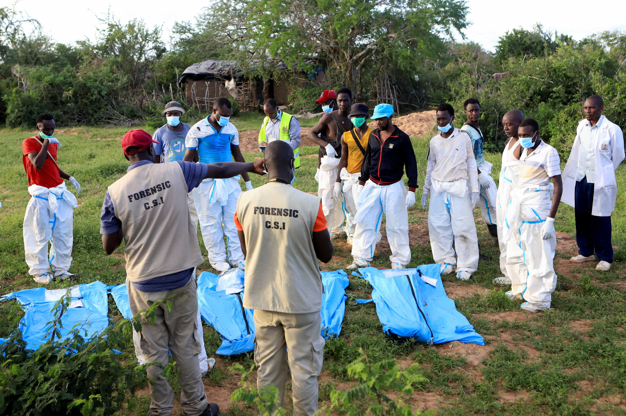 Forensic experts and homicide detectives from the Directorate of Criminal Investigations (DCI), sort exhumed bodies of suspected followers of a Christian cult named Good News International Church, who believed that they would go to heaven if they starved themselves to death, in Shakahola forest of Kilifi county, Kenya May 11, 2023. REUTERS