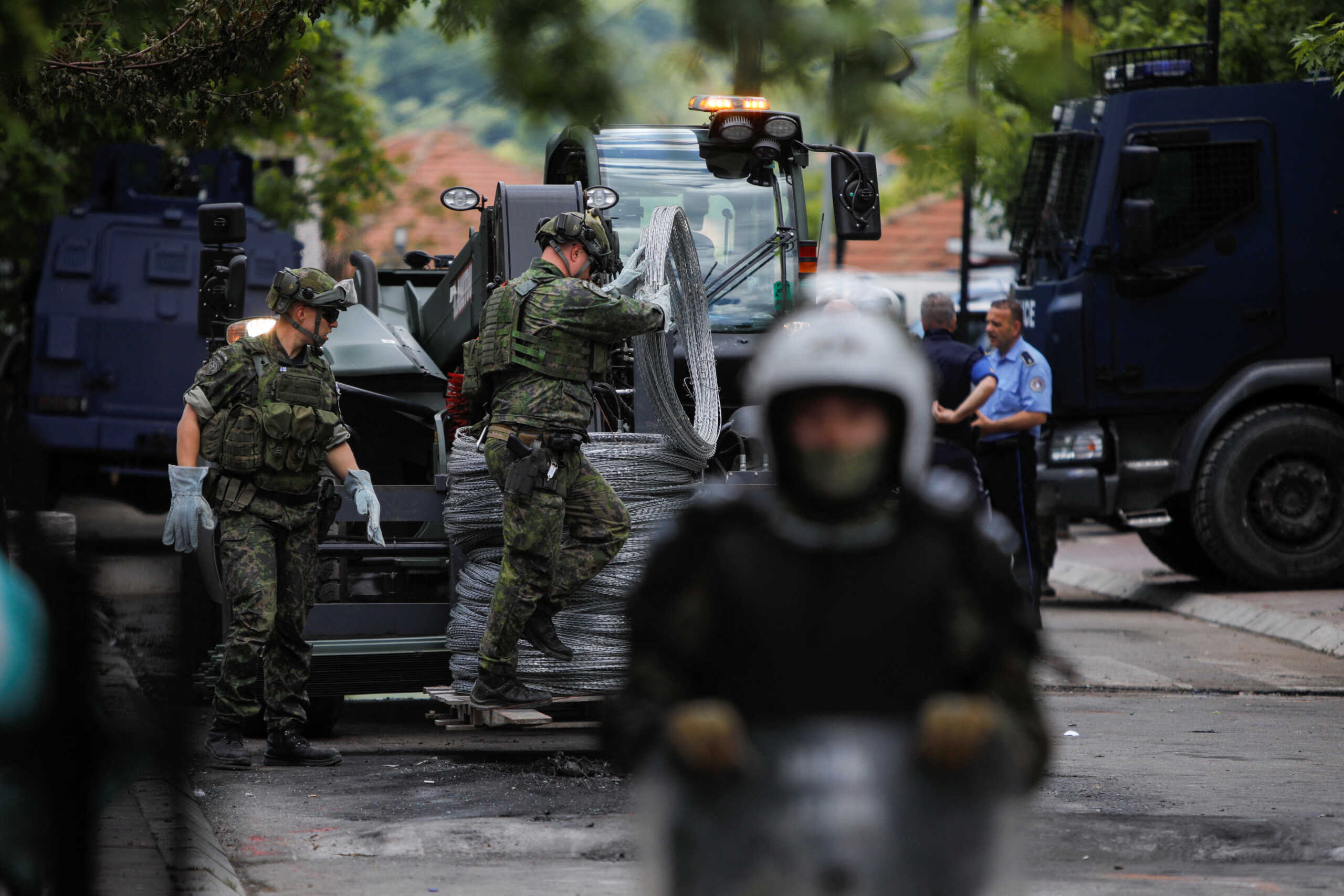 Kosovo Force (KFOR) soldiers prepare barbed wire near a municipal office in Zvecan, Kosovo May 30, 2023. REUTERS