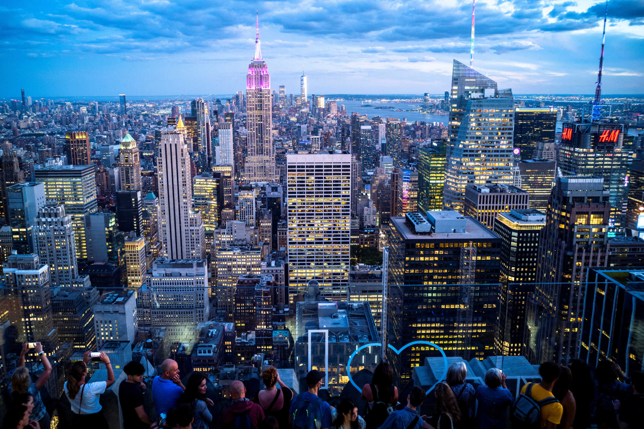 FILE PHOTO: People enjoy the Manhattan skyline during sunset, from the Top of the Rock observation deck, at Rockefeller Center, in New York, U.S., June 28, 2022. REUTERS