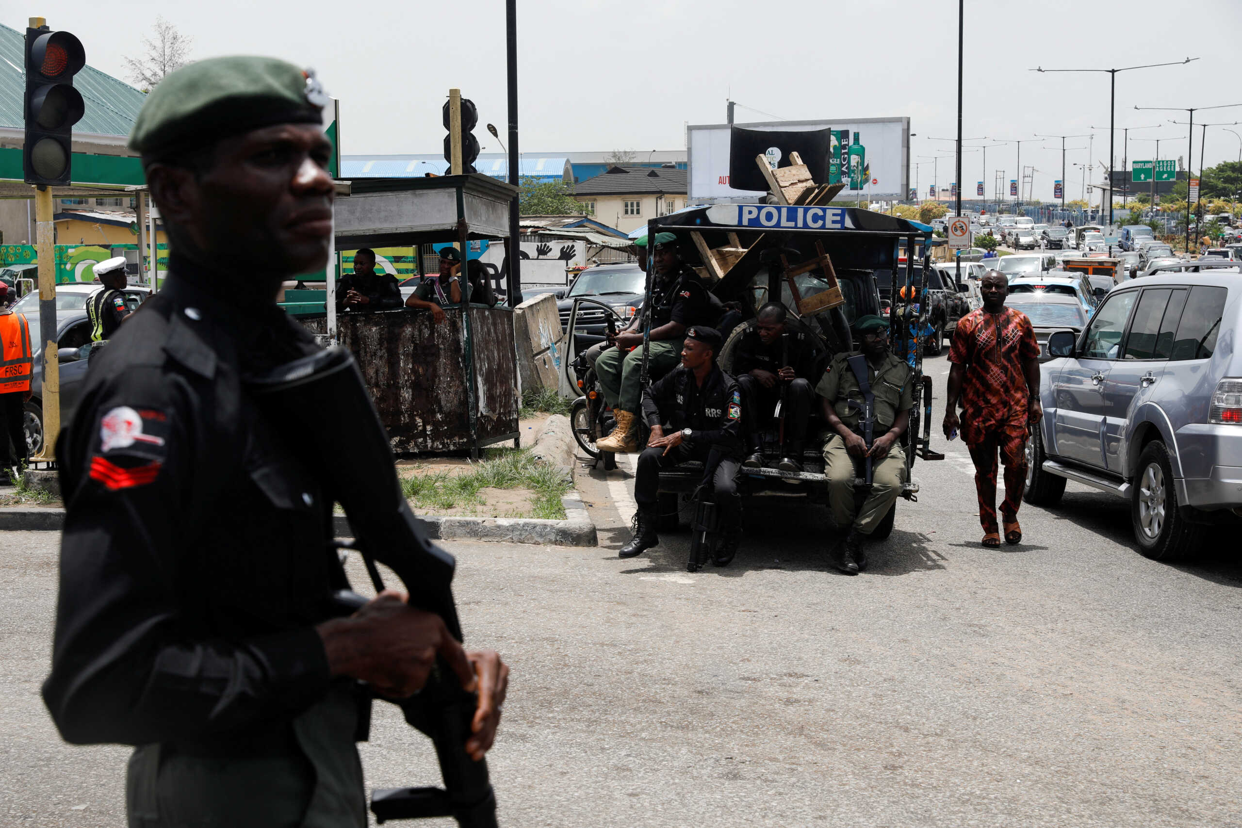 A man walks past police officers in position, as protesters block the domestic terminal of Murtala Muhammed International Airport during a strike over working conditions and wages, in Lagos, Nigeria April 17, 2023. REUTERS
