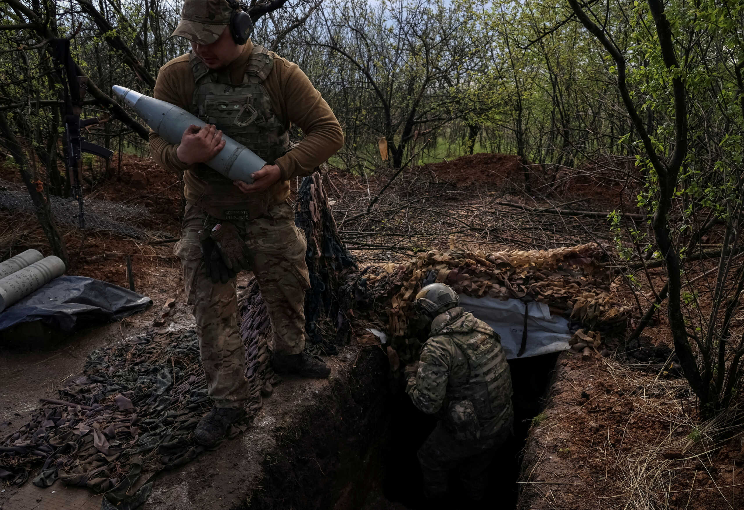 FILE PHOTO: A Ukrainian service member from a 3rd separate assault brigade of the Armed Forces of Ukraine, carries a shell as they prepare to fire a howitzer D30 at a front line, amid Russia's attack on Ukraine, near the city of Bakhmut, Ukraine April 23, 2023. REUTERS