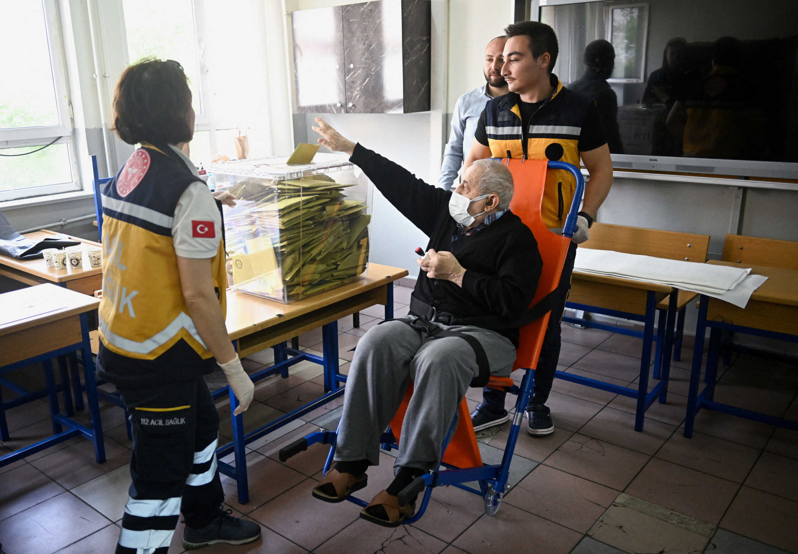A man, who was picked up by ambulance form home and taken to vote as he was not well enough to travel on own, casts his vote  at a polling station during the presidential and parliamentary elections, in Istanbul, Turkey May 14, 2023. REUTERS