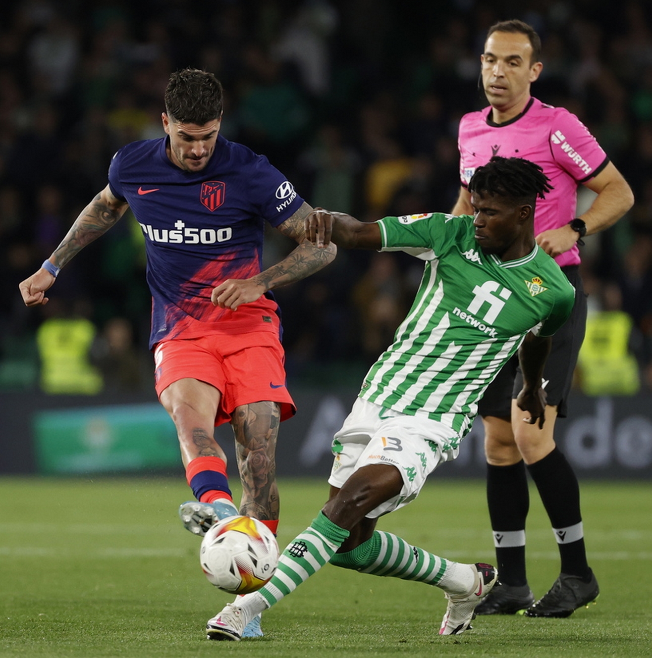 epa09806481 Real Betis' Paul Akouokou (R) in action against Atletico de Madrid's Rodrigo de Paul (L) during a Spanish LaLiga soccer match between Real Betis and Atletico Madrid at Benito Villamarin stadium in Sevilla, southern Spain, 06 March 2022.  EPA