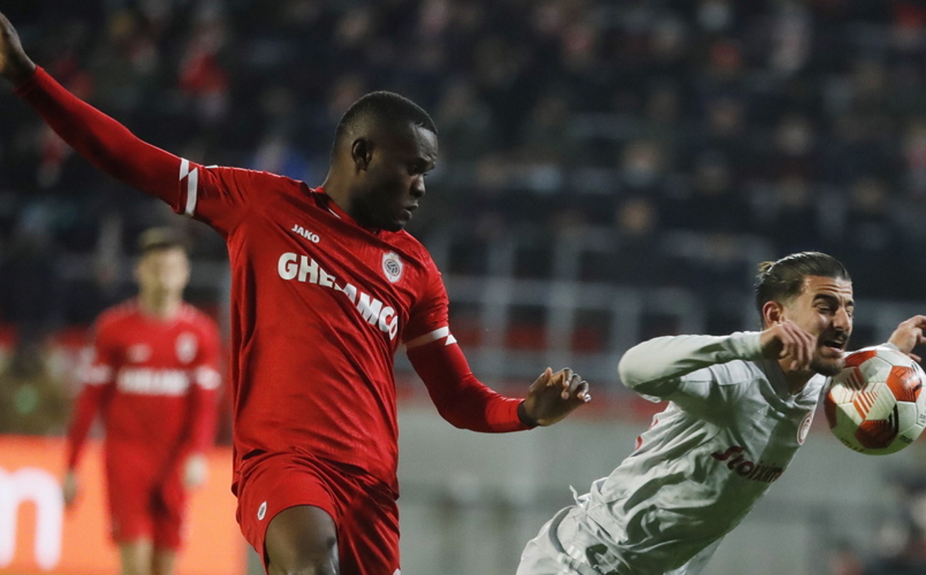 epa09632466 Ally Mbwana Samatta (L) of Antwerp in action against Thanasis Androutsos of Olympiacos during the UEFA Europa League Group D match between Royal Antwerp and Olympiacos Piraeus in Antwerp, Belgium, 09 December 2021.  EPA