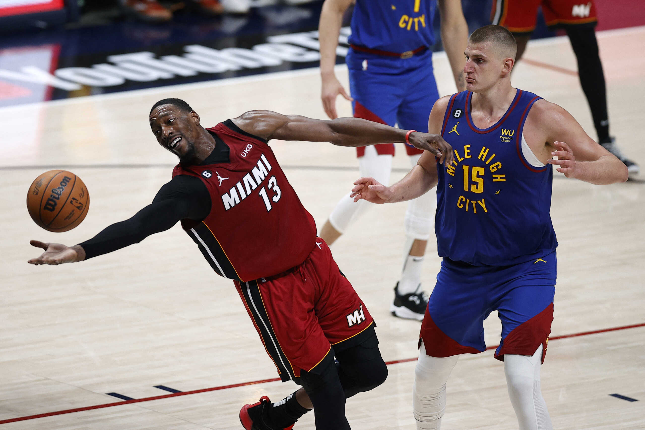 Jun 1, 2023; Denver, CO, USA; Miami Heat center Bam Adebayo (13) reaches for the ball as Denver Nuggets center Nikola Jokic (15) looks on during the fourth quarter in game one of the 2023 NBA Finals at Ball Arena. Mandatory Credit: Isaiah J. Downing-USA TODAY Sports
