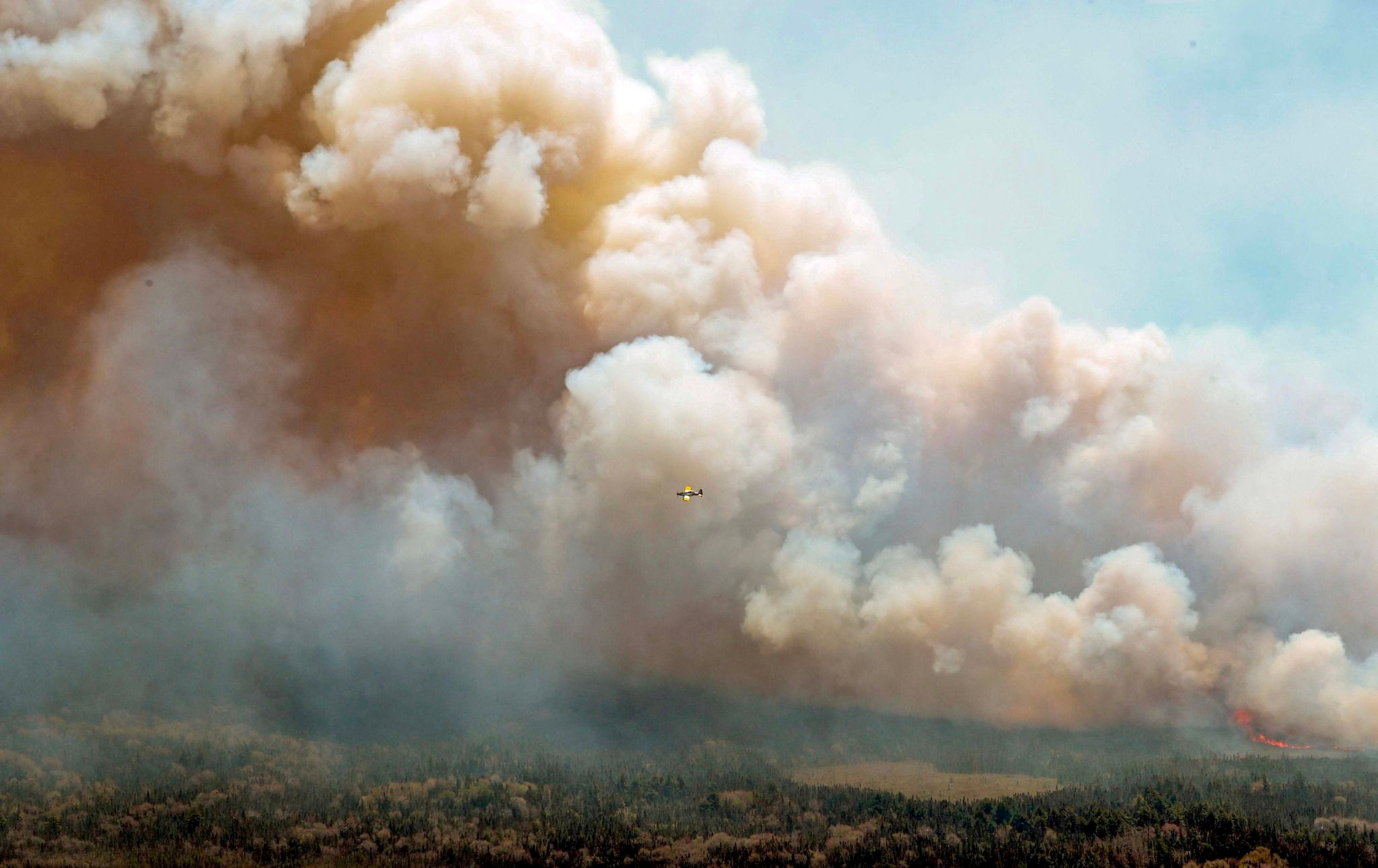 New Brunswick aircraft drops a mix of water and fire retardant as it passes over the wildfire in Barrington Lake, Nova Scotia, Canada in this social media handout image released May 31, 2023. Nova Scotia Government