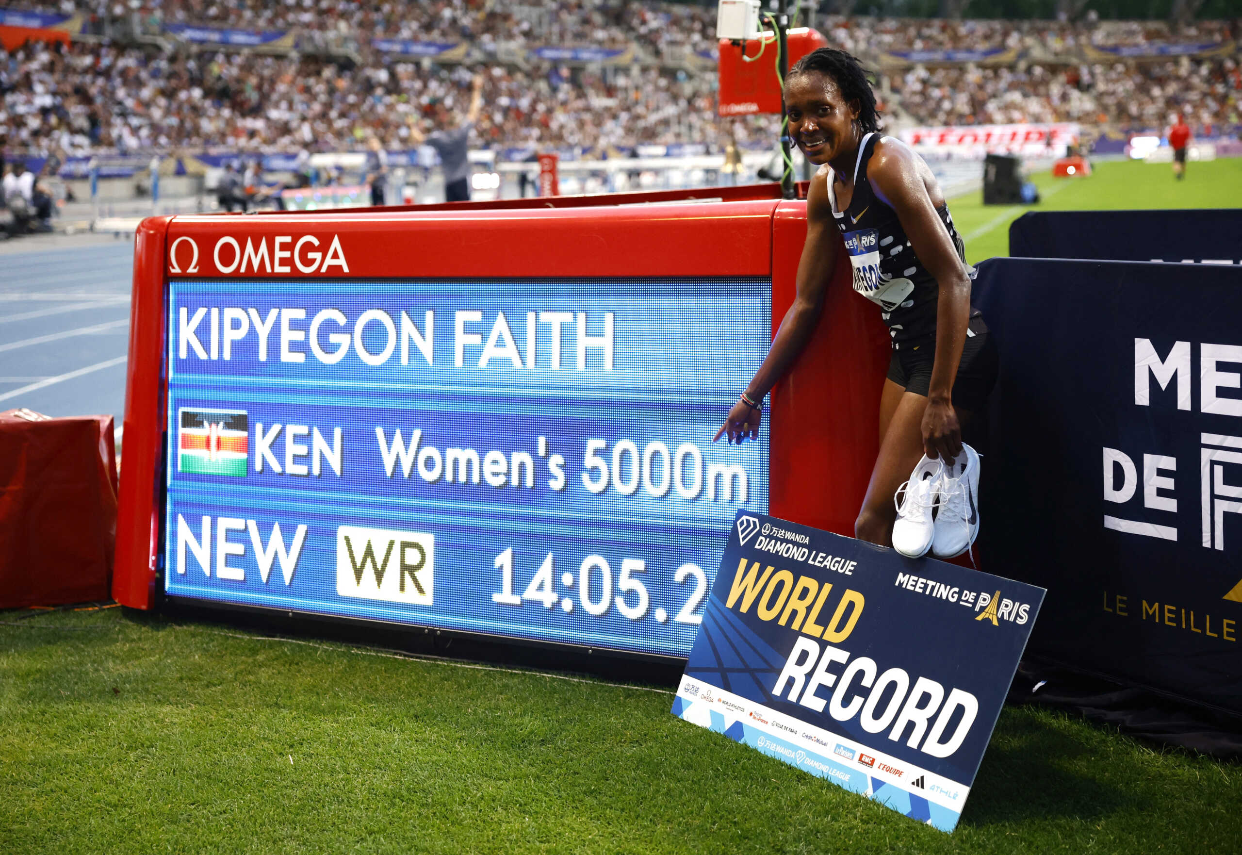 Athletics - Diamond League - Meeting de Paris - Stade Charlety, Paris, France - June 9, 2023 Kenya's Faith Kipyegon poses with the screen as she sets a new world record and wins the the women's 5000m REUTERS