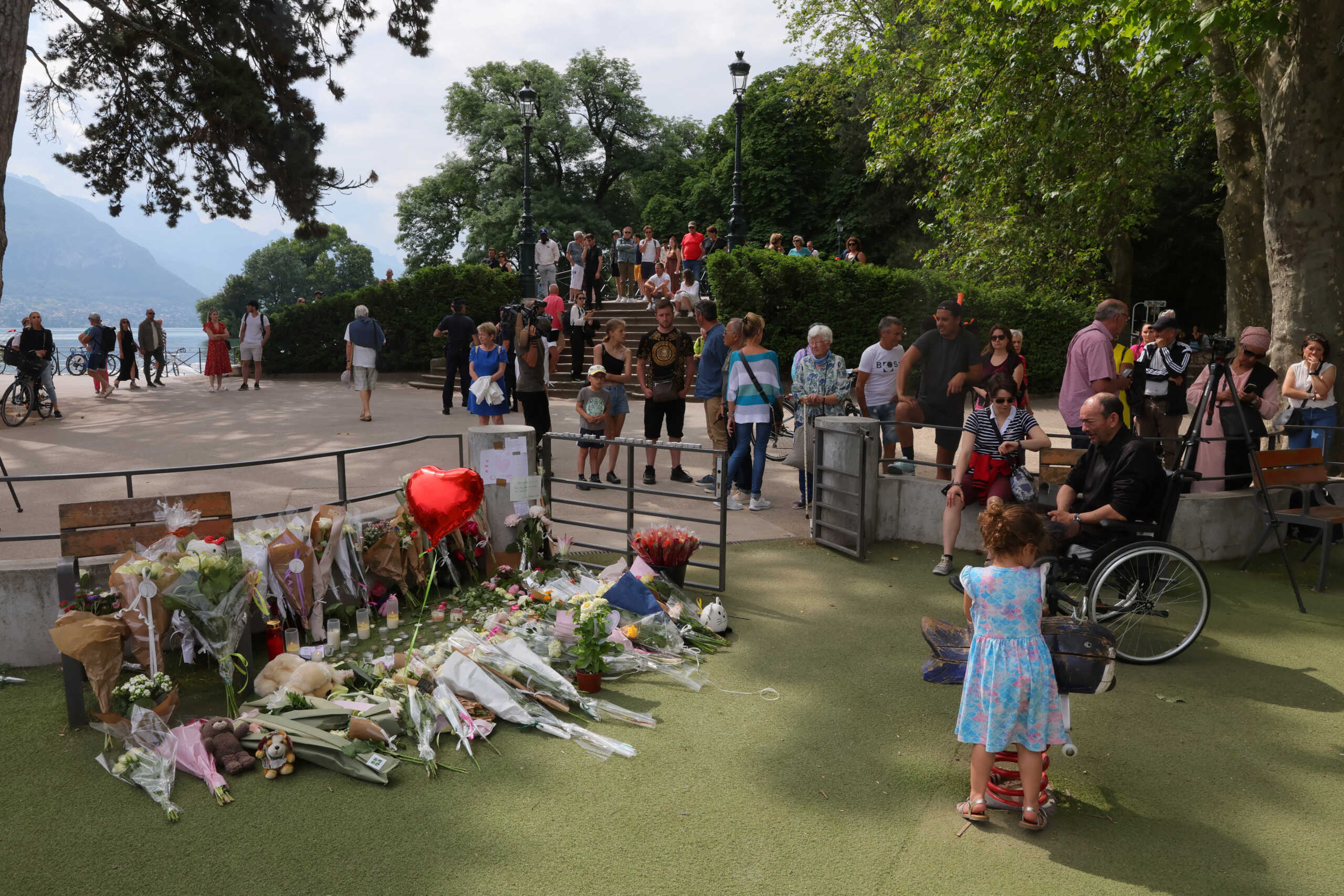 People pay respect in front of messages and floral tributes at the children's playground the day after several children and adults were injured in a knife attack at the Le Paquier park near the lake in Annecy, in the French Alps, France, June 9, 2023. REUTERS