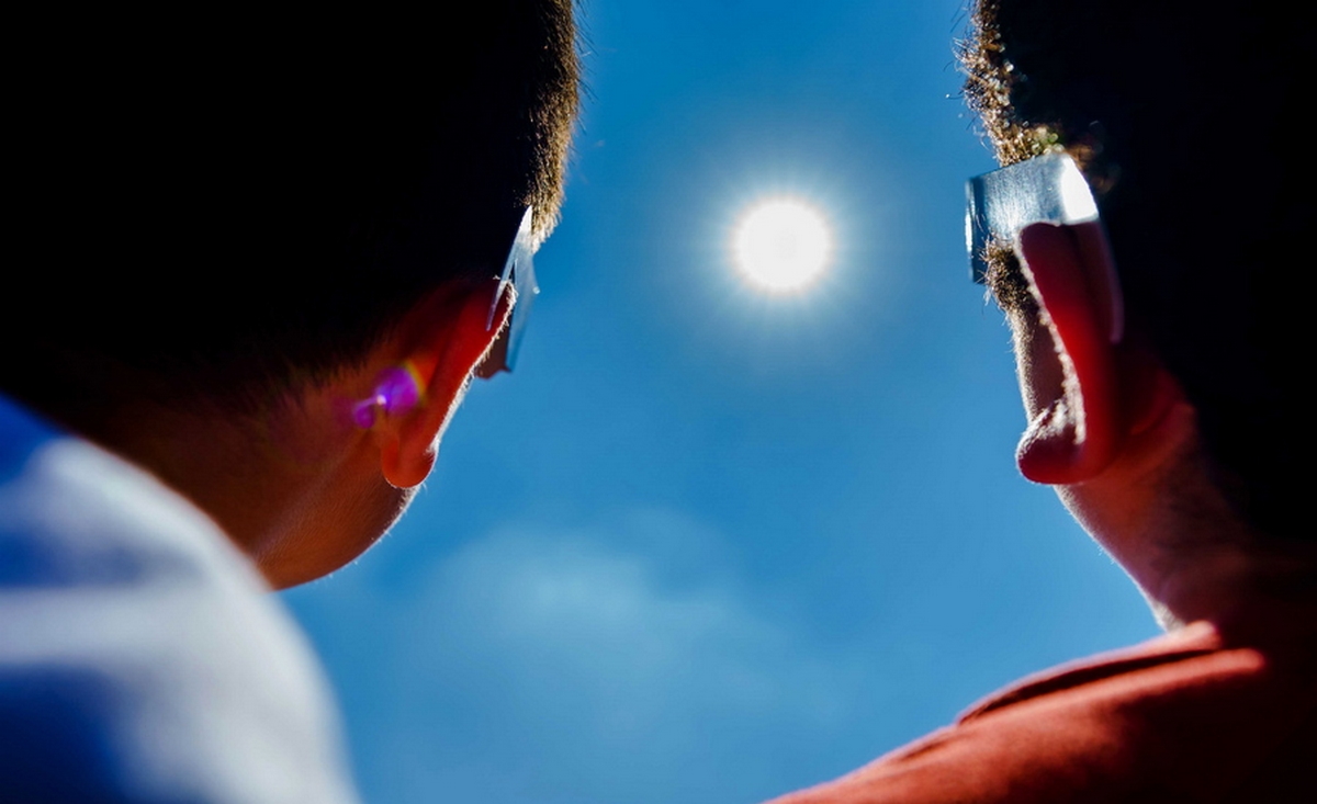 epa09259474 Pupils of primary school IBS Ababil, look at the solar eclipse with special glasses, in Schiedam, The Netherlands, 10 June 2021. For the first time since 2015, a partial solar eclipse can be seen again, with the sun partly obscured by the moon.  EPA