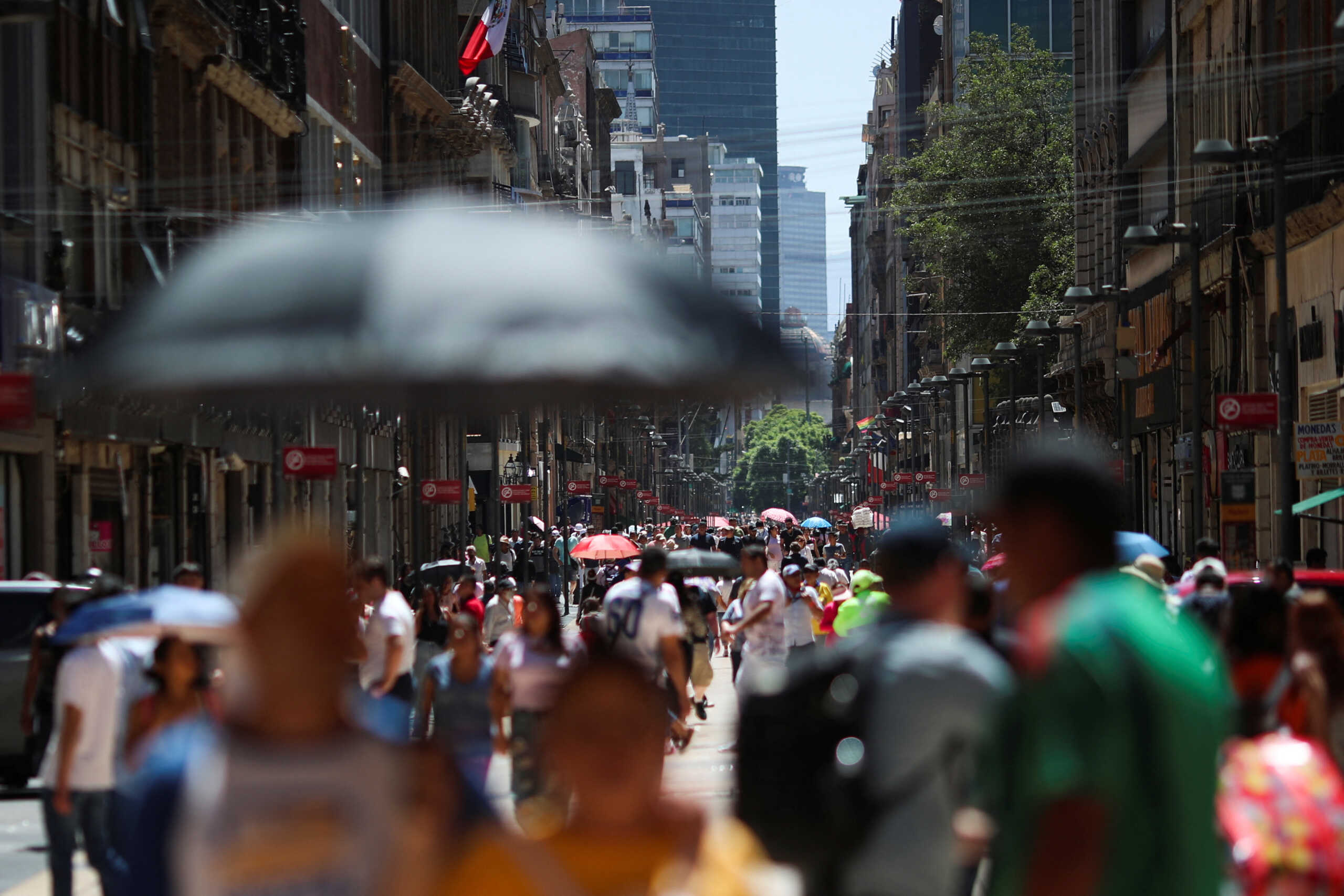 People hold umbrellas as they cover themselves from the heat during a period of high temperatures in Mexico City, Mexico June 13, 2023. REUTERS
