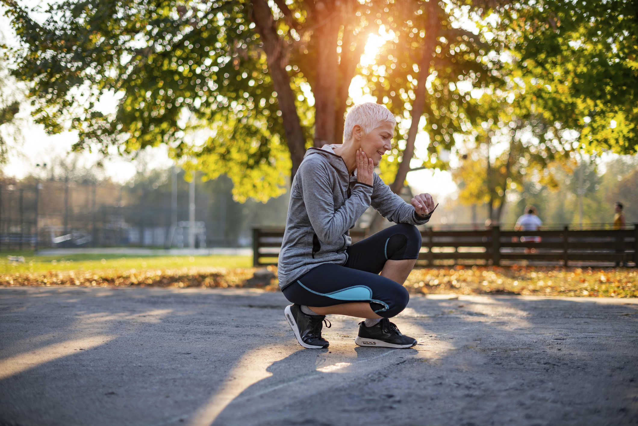 Senior Athletic Woman Checking Heart Rate After Running in the Park. Portrait of Mature Woman Check Her Pulse on Neck while Taking Break From Jogging