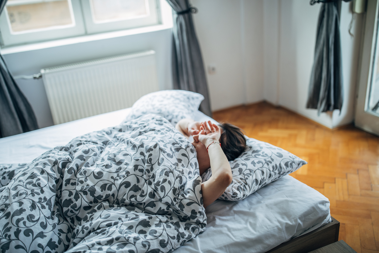 Young woman is waking up in the morning and rubbing her eyes.