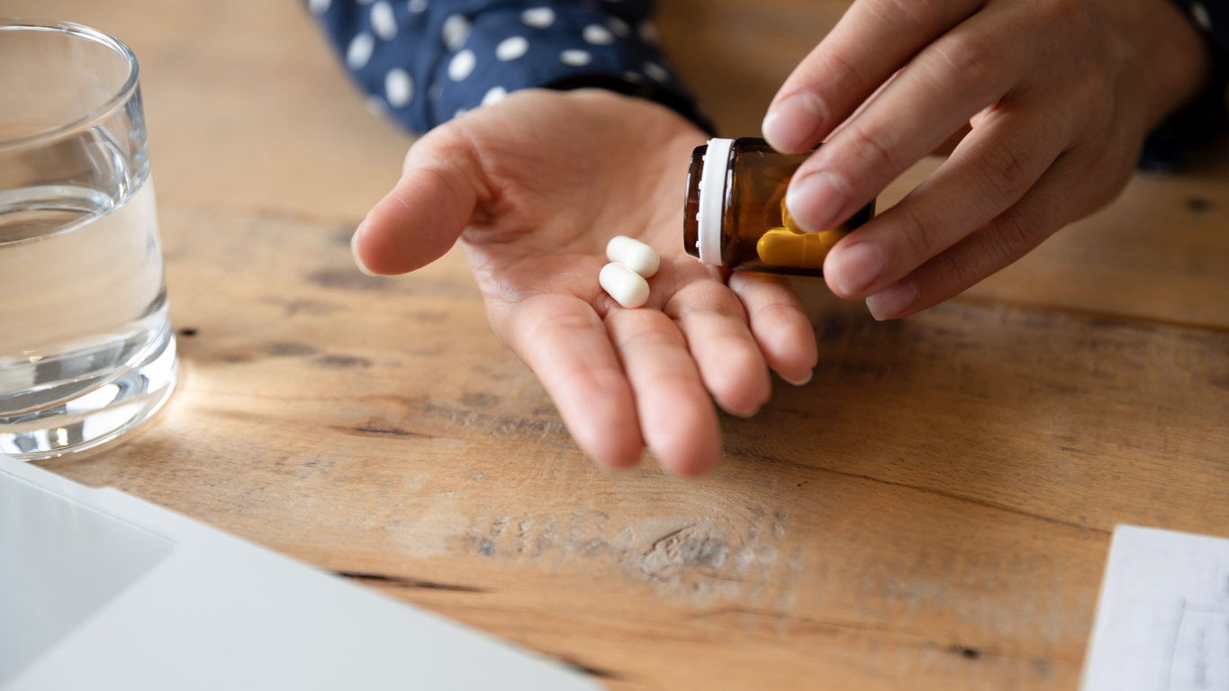 Close up of unhealthy young woman take antibiotics or antidepressant at home, unwell millennial female feel ill drink prescribed medicines from bottle, daily dosage of vitamins, medication concept