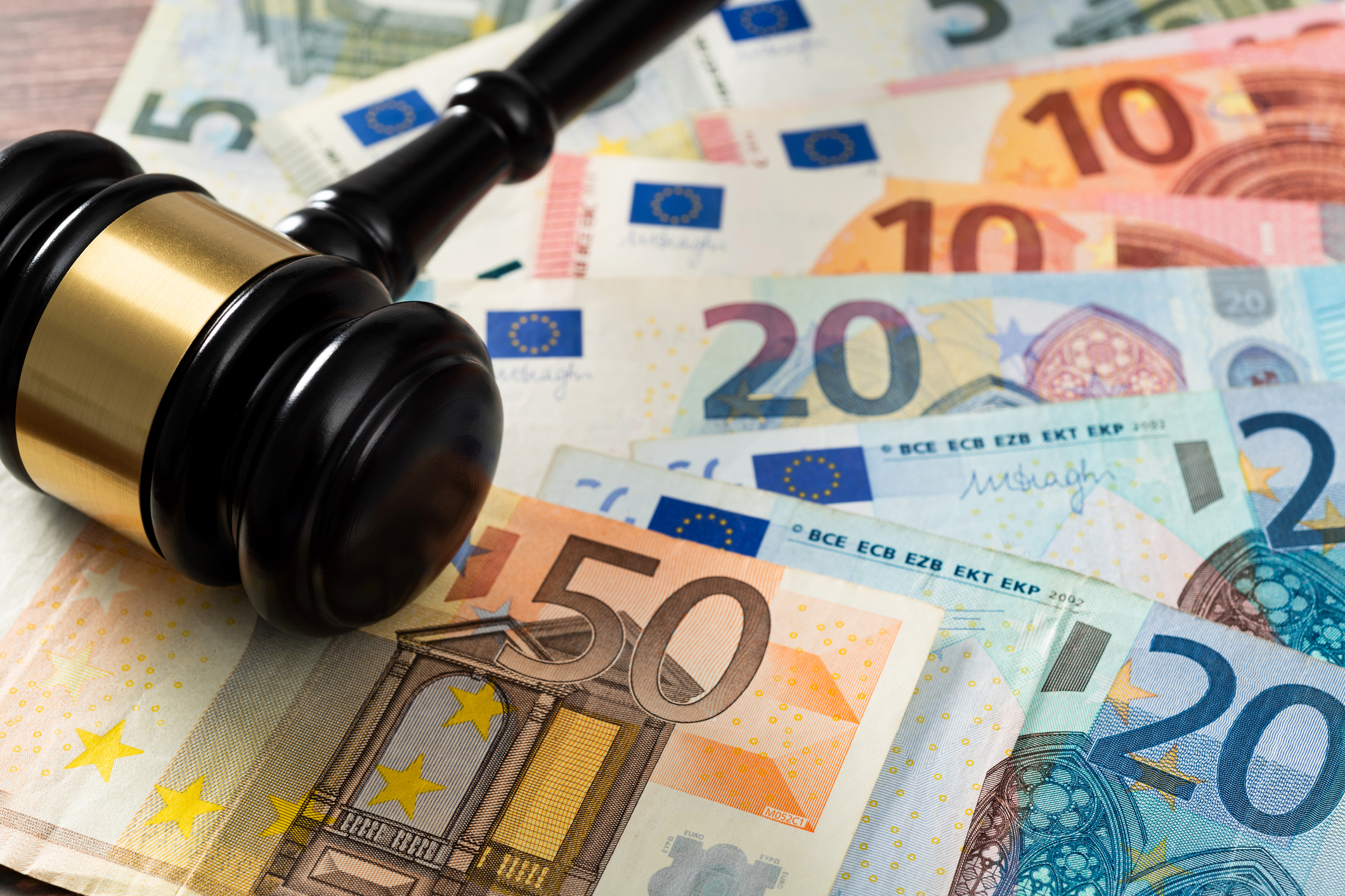 Gavel and stack European Union currency on the table.