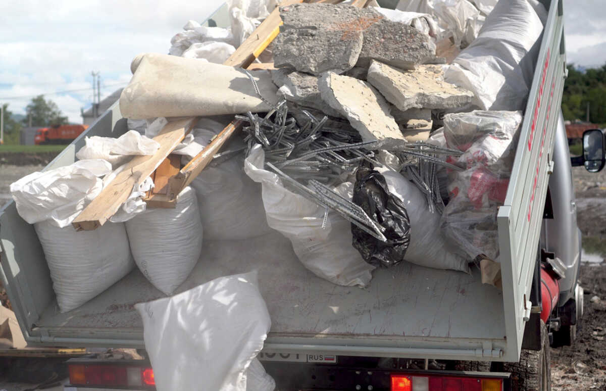A dump truck unloads construction waste. The machine lifts the body and drops the garbage bags. 4k