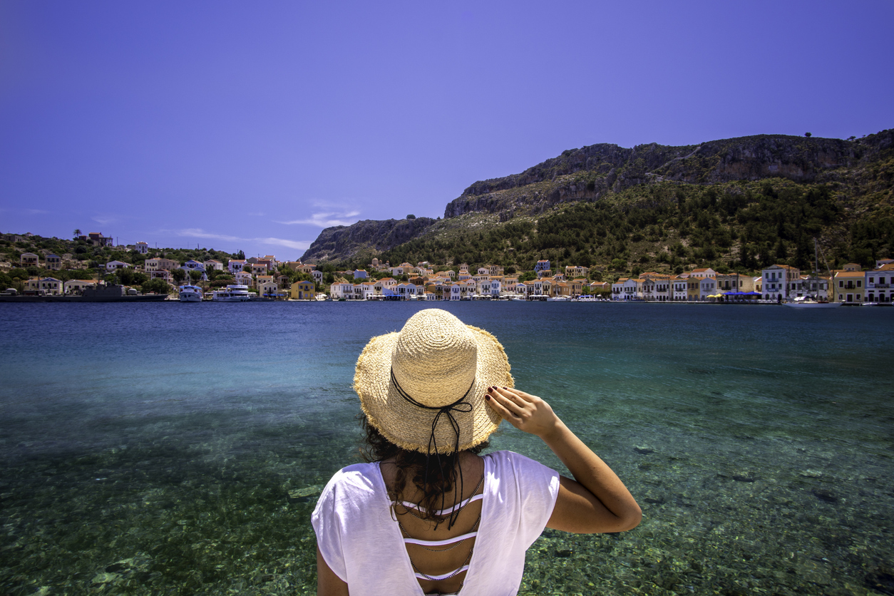 Young woman at shore of Megisti (Kastellorizo) Island, Greece.