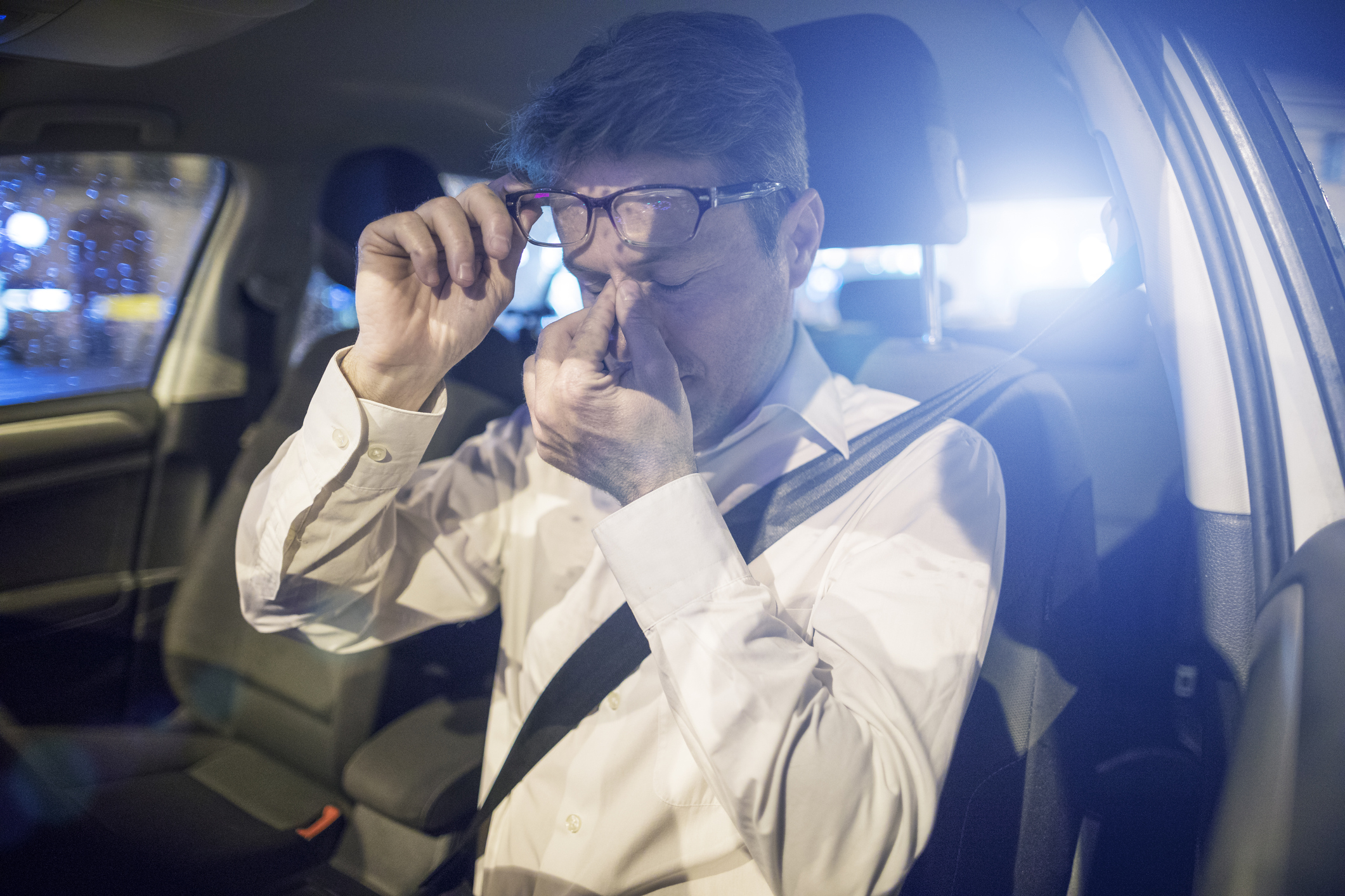Tired driver inside car at night