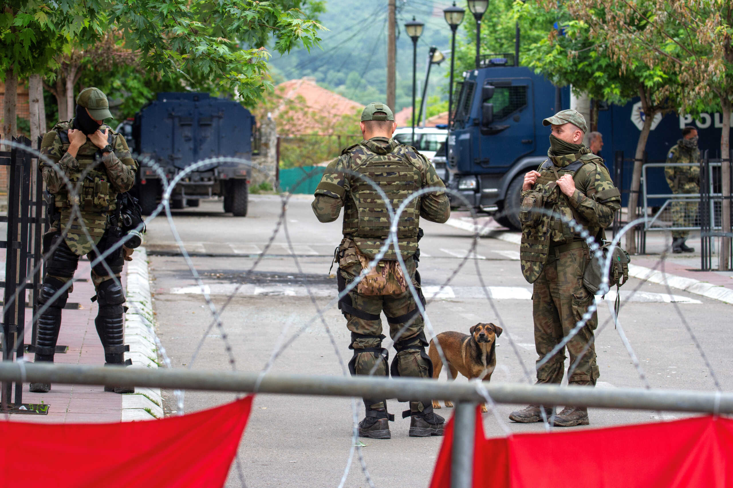NATO Kosovo Force (KFOR) soldiers stand guard behind razor wire fence in the town of Zvecan, Kosovo, June 5, 2023. REUTERS