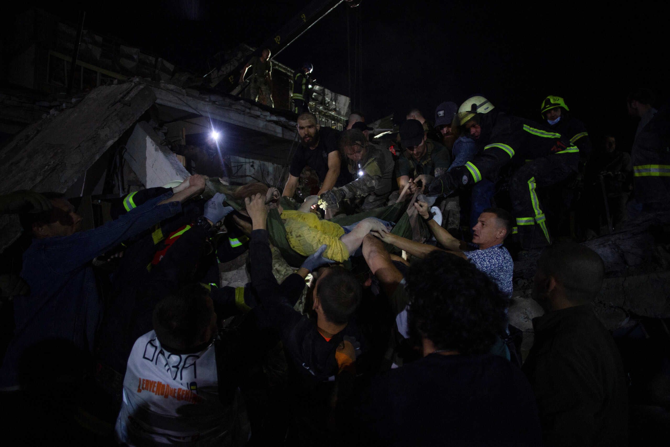 Rescues and volunteers carry a woman rescued from the debris at the site of hotel and restaurant buildings heavily damaged by a Russian missile strike, amid Russia's attack on Ukraine, in central Kramatorsk, Donetsk region, Ukraine June 27, 2023. REUTERS