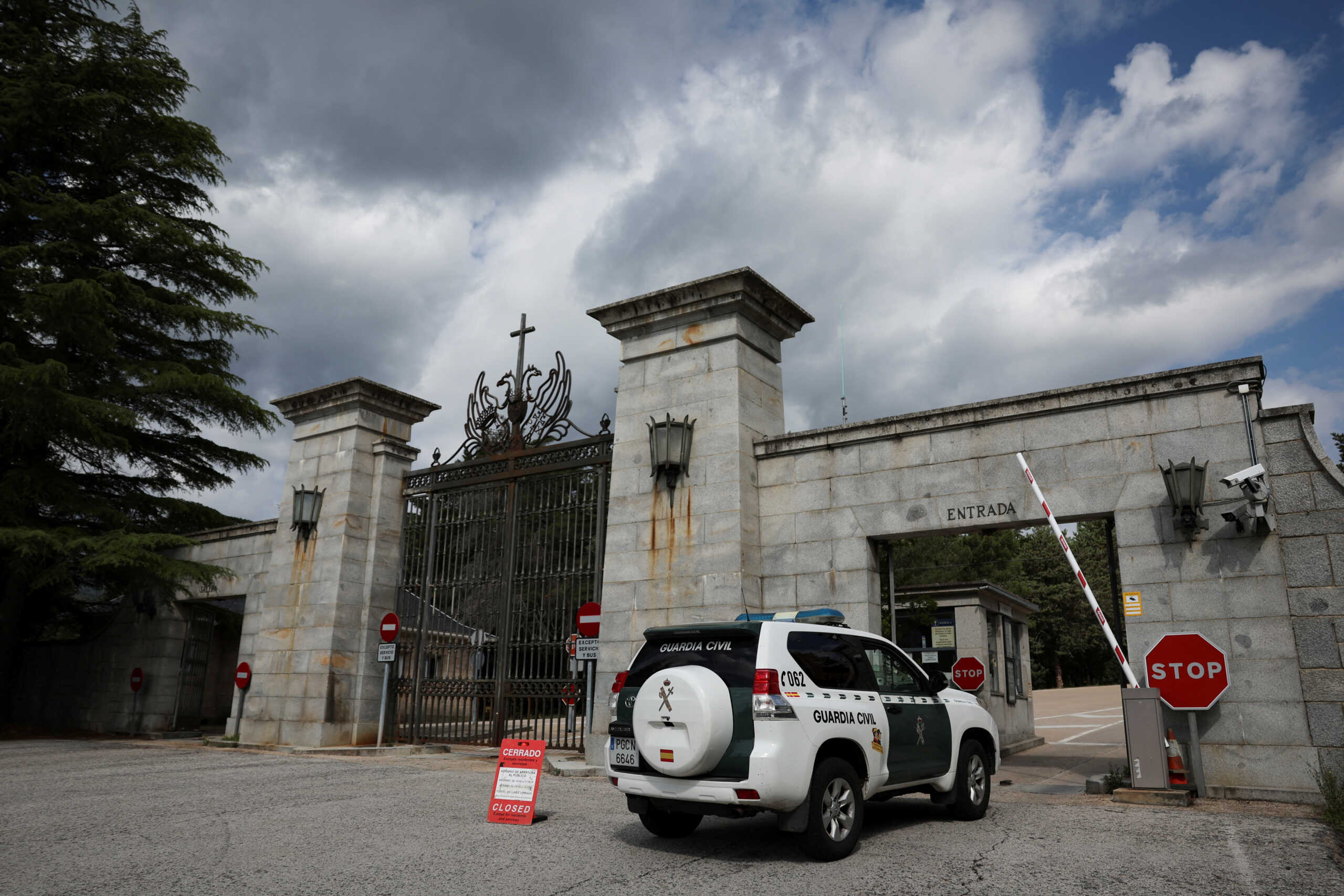 A police vehicle passes a sign informing visitors that the 'Valley of the Fallen' monument, now known as Valley of Cuelgamuros, is closed to the general public as forensic scientists begin work to remove the remains of 128 victims of the Spanish Civil War who are buried at the site, near Madrid, Spain, June 12, 2023. REUTERS