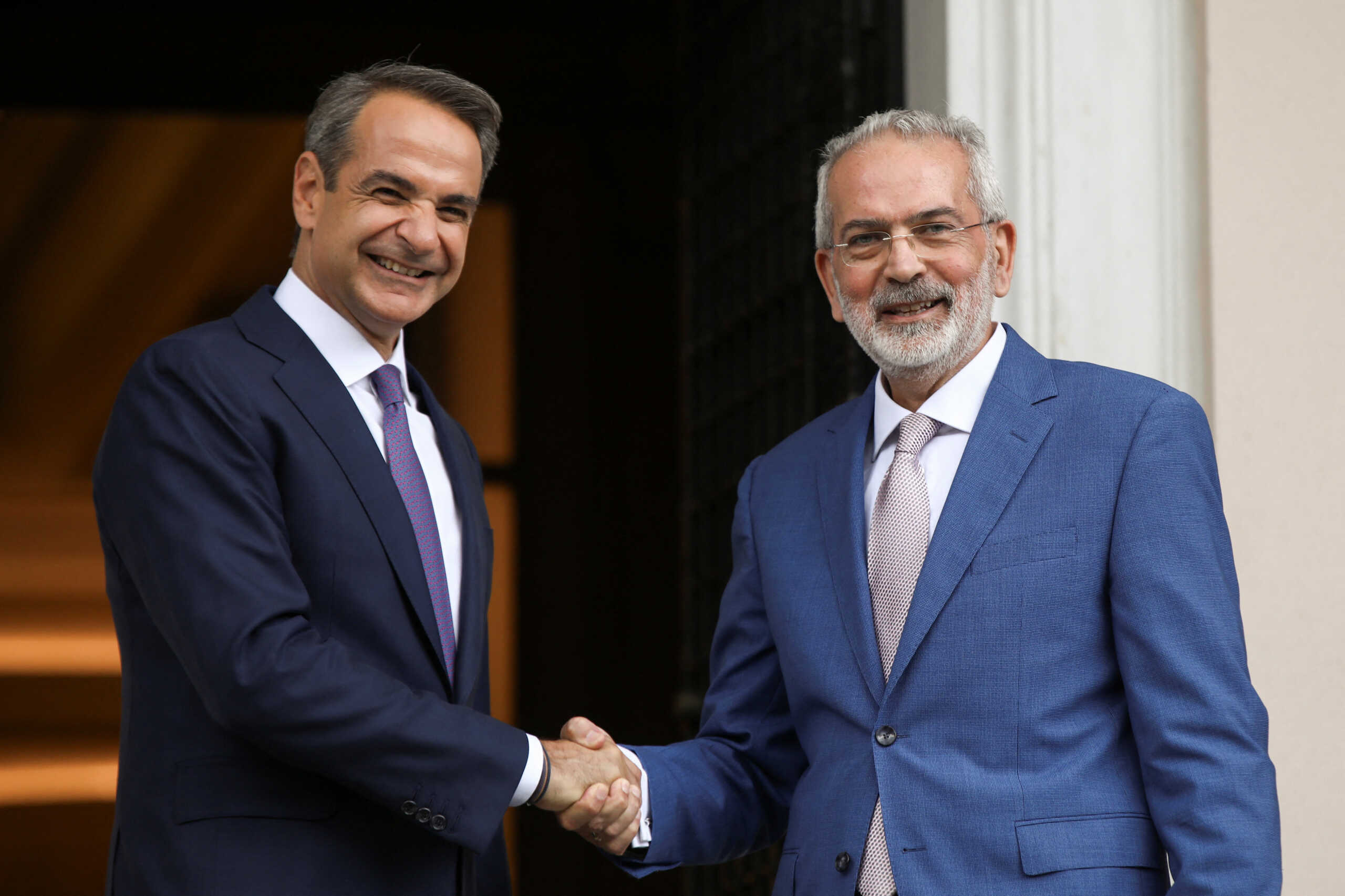 Newly sworn-in Greek Prime Minister Kyriakos Mitsotakis shakes hands with caretaker Prime Minister Ioannis Sarmas, during a handover ceremony at the Maximos Mansion in Athens, Greece, June 26, 2023. REUTERS