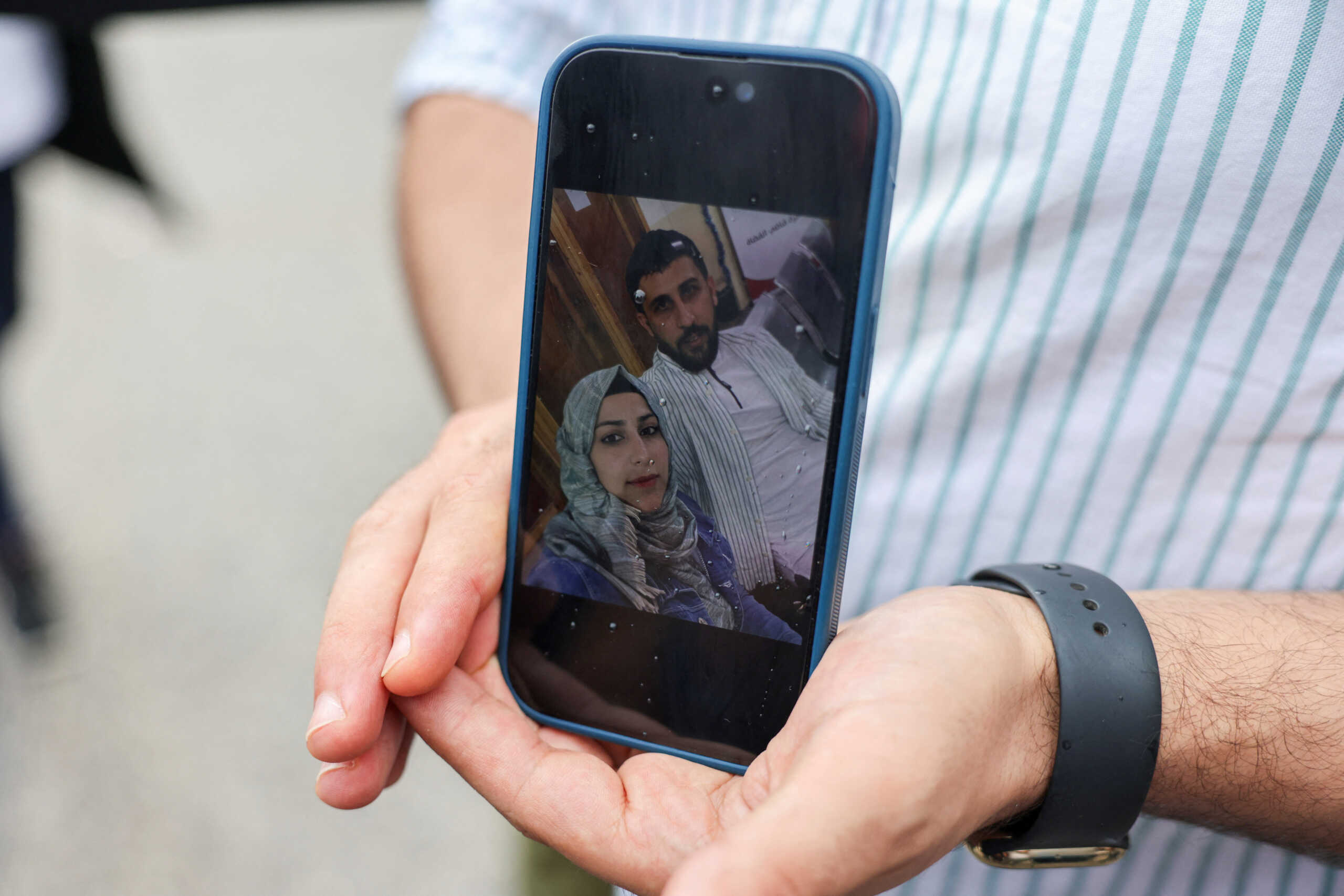Syrian Kassam Abozeed, 34, who says his wife Israa and brother-in-law were onboard a boat with migrants that capsized at open sea off Greece, demonstrates a photo of him and his wife, at the port of Kalamata, Greece, June 15, 2023. REUTERS