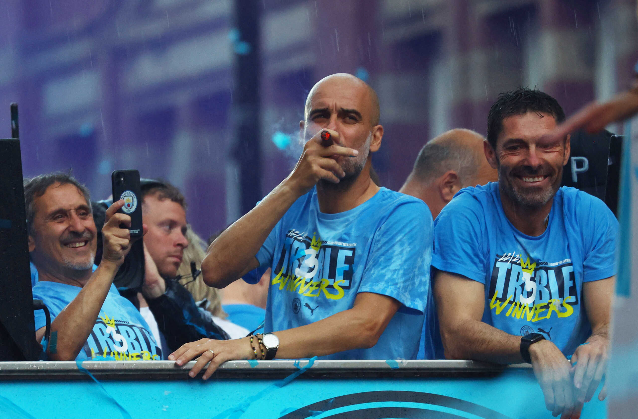Soccer Football - Manchester City Victory Parade - Manchester, Britain - June 12, 2023 Manchester City manager Pep Guardiola is pictured smoking a cigar during the parade REUTERS