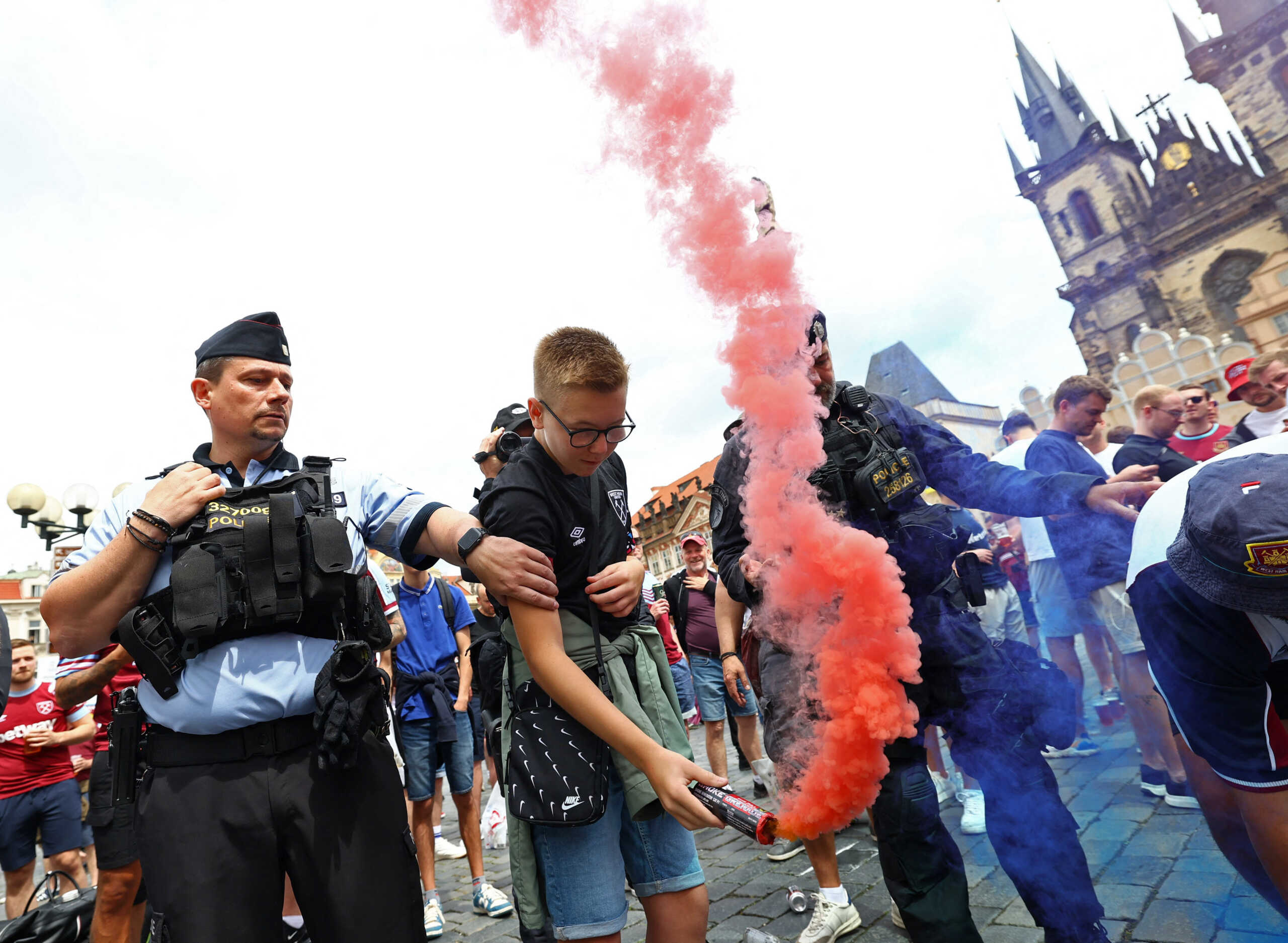 Soccer Football - Europa Conference League - Final - Fiorentina v West Ham United - Prague, Czech Republic - June 7, 2023 A West Ham United fan holding a flare is spoken to by a police officer ahead of the match REUTERS