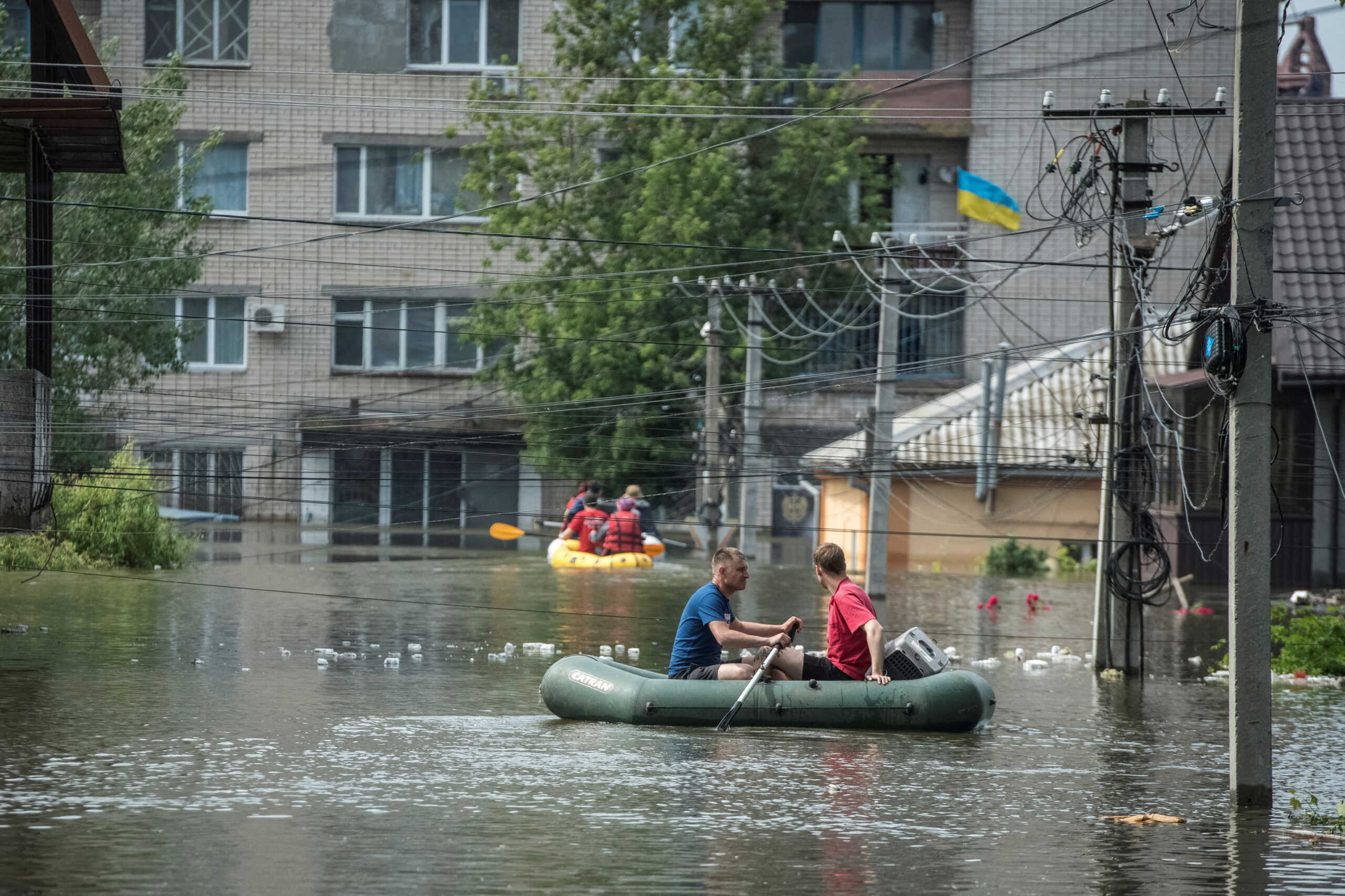 Local residents sail on boats at a flooded street during an evacuation from a flooded area after the Nova Kakhovka dam breached, amid Russia's attack on Ukraine, in Kherson, Ukraine June 8, 2023. REUTERS