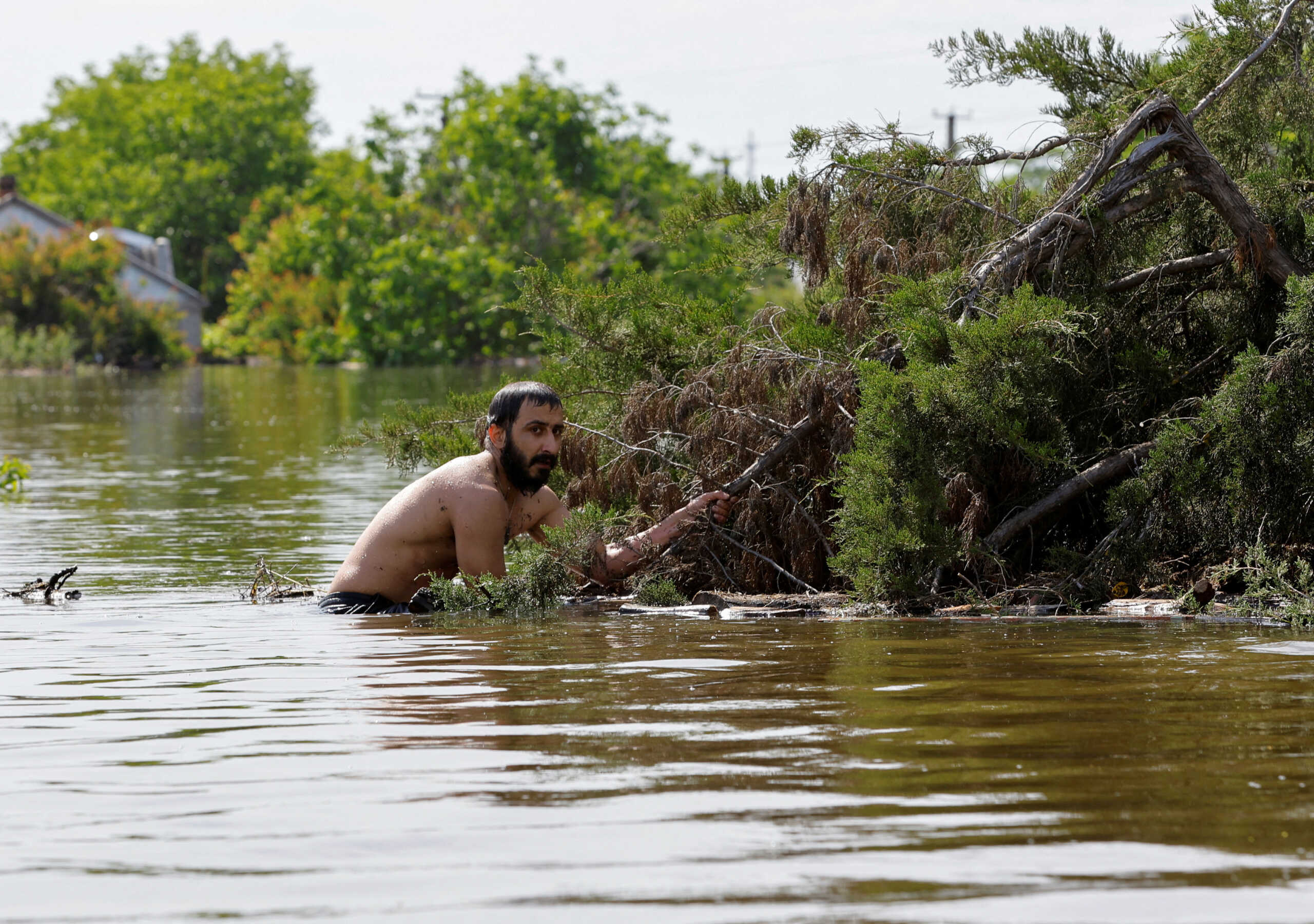 A man intending to offer assistance to local residents moves amid a flooded residential area, that is submerged in water following the collapse of the Nova Kakhovka dam in the course of the Russia-Ukraine conflict, in the settlement of Korsunka in the Kherson region, Russian-controlled Ukraine, June 7, 2023. REUTERS