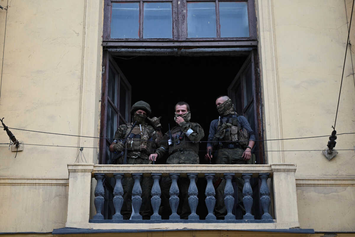 Fighters of Wagner private mercenary group stand on a balcony while being deployed at the headquarters of the Southern Military District in the city of Rostov-on-Don, Russia, June 24, 2023. REUTERS