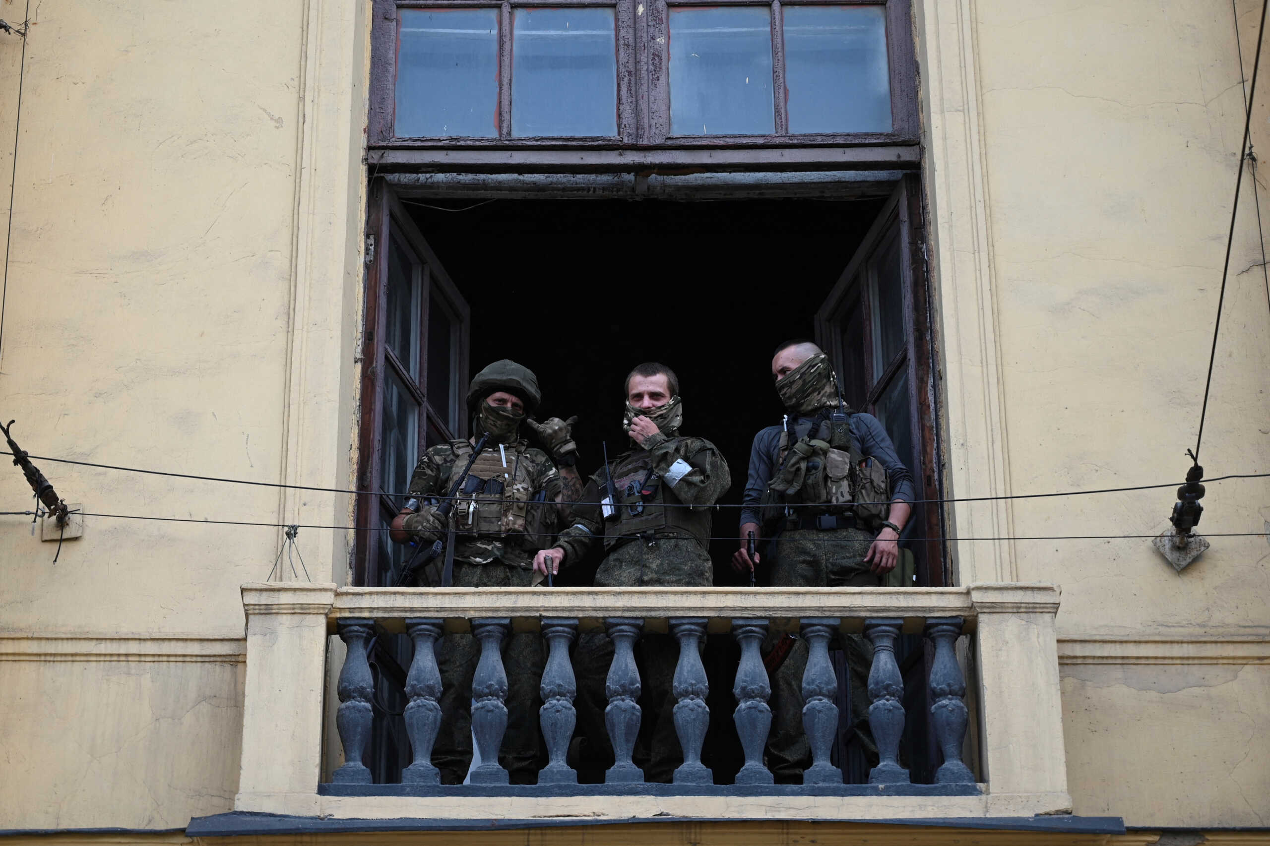 Fighters of Wagner private mercenary group stand on a balcony while being deployed at the headquarters of the Southern Military District in the city of Rostov-on-Don, Russia, June 24, 2023. REUTERS