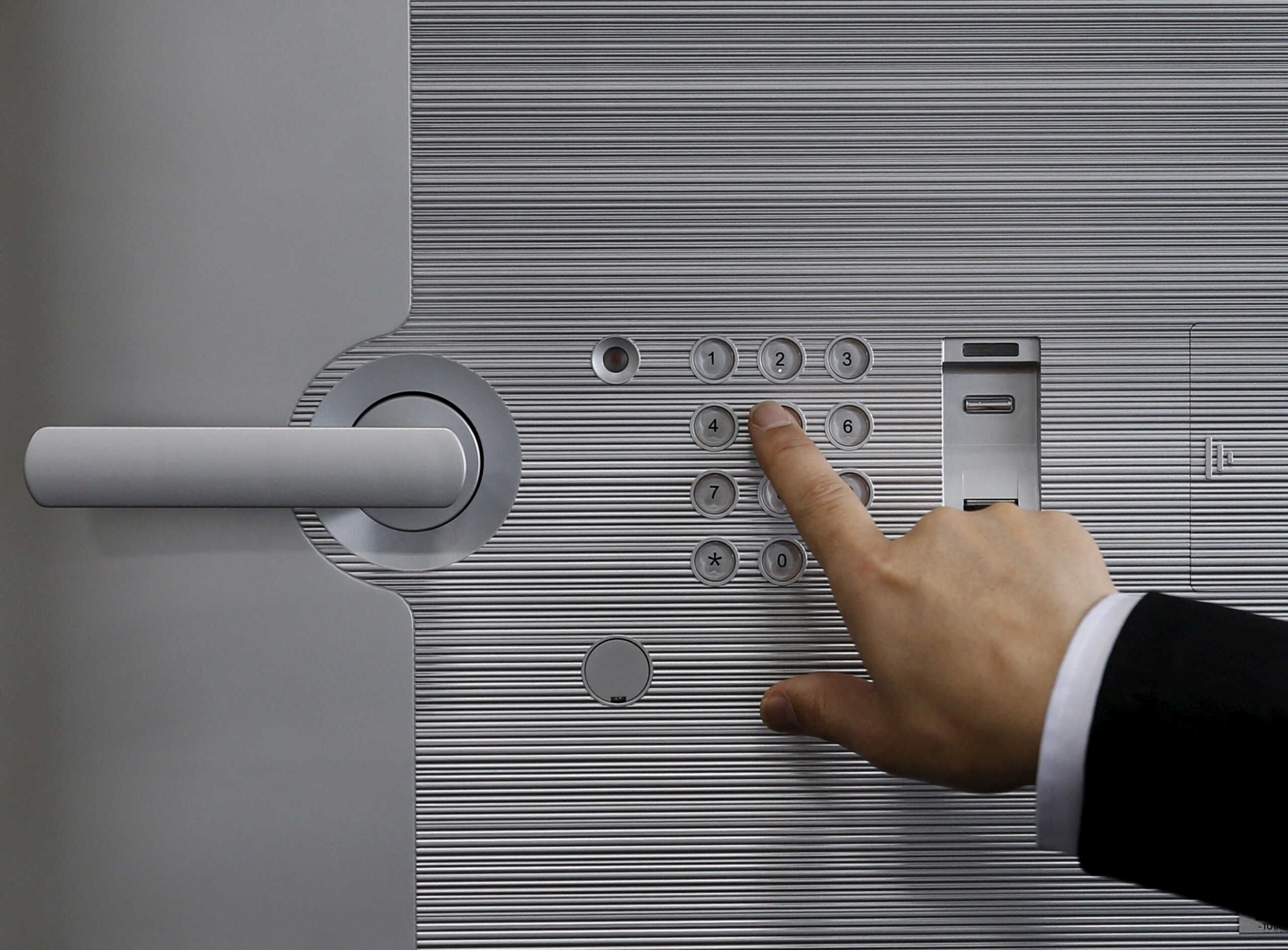 FILE PHOTO: A staff enters a pass code for a safety deposit box during a photo opportunity at a security showroom in Tokyo, Japan, March 23, 2016. REUTERS