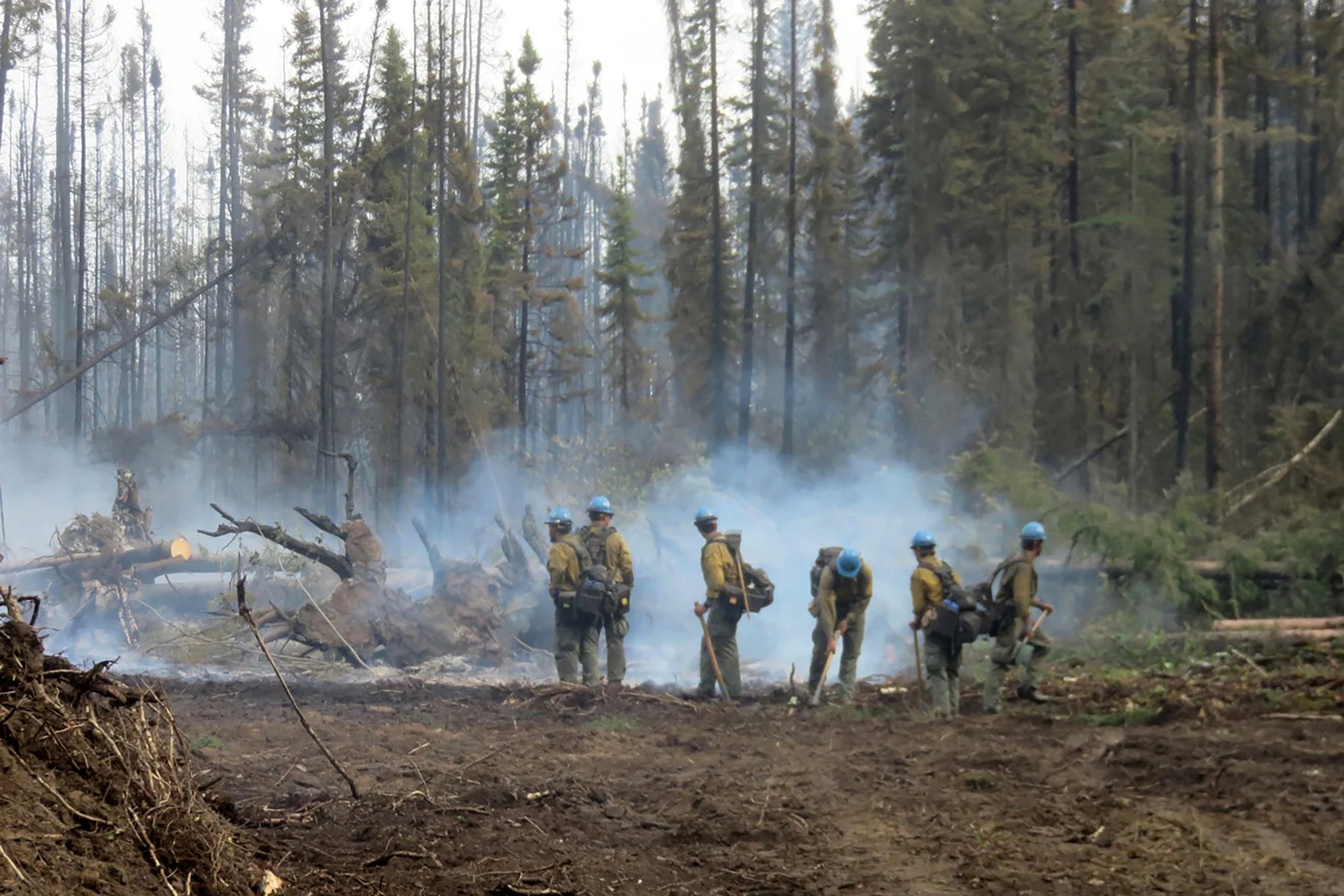 American firefighters work on the Basset Complex wildfire near Paddle Prairie Metis Settlement, Alberta, Canada July 10, 2023. Alberta Wildfire