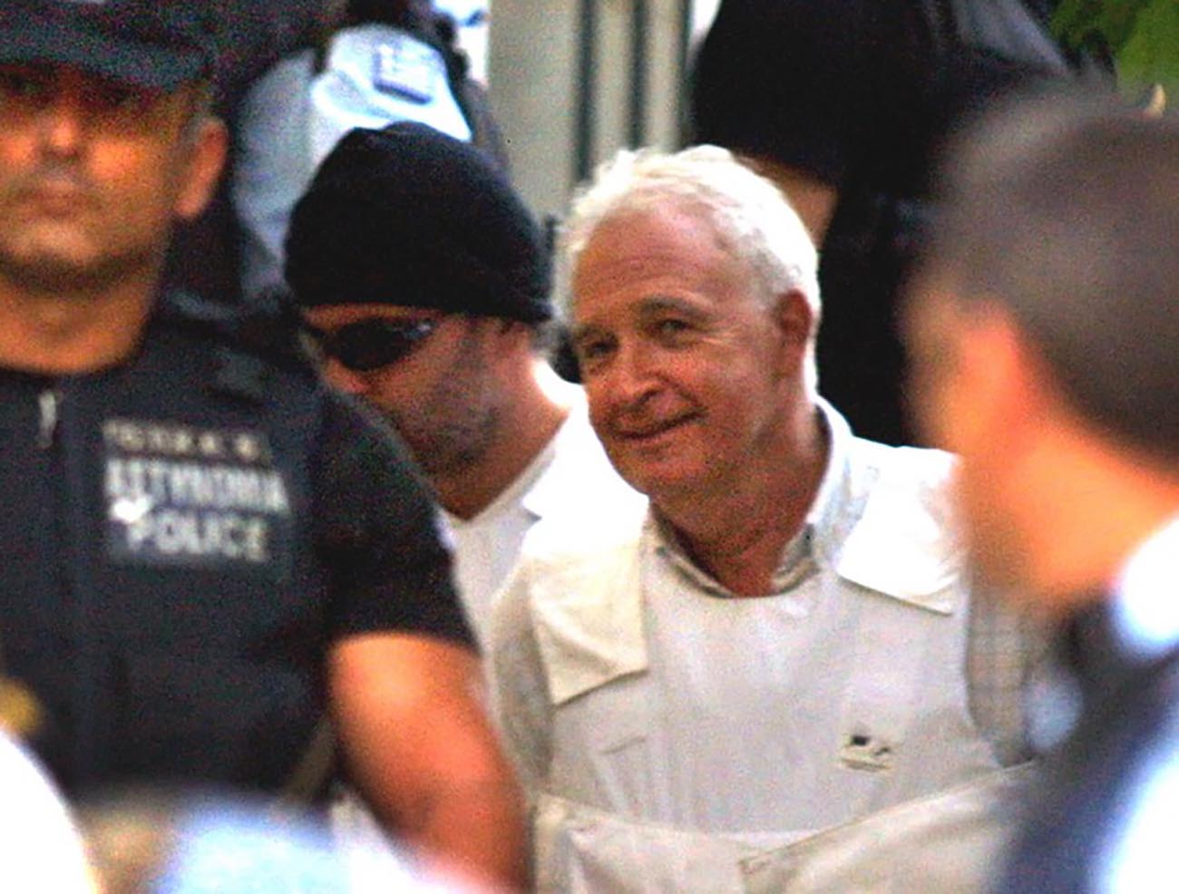 GRE06 - 20020723 - ATHENS, GREECE: (FILES) Picture dated 23 July 2002 of Alexandros Yotopoulos (R), the suspected mastermind of the terrorist group 'November 17', being led by police to the prosecutors' office for a hearing in Athens. Yotopoulos on Wednesday, 24 July 2002, rejected any involvement and accused police of fabricating allegations against him. 
EPA PHOTO EPA