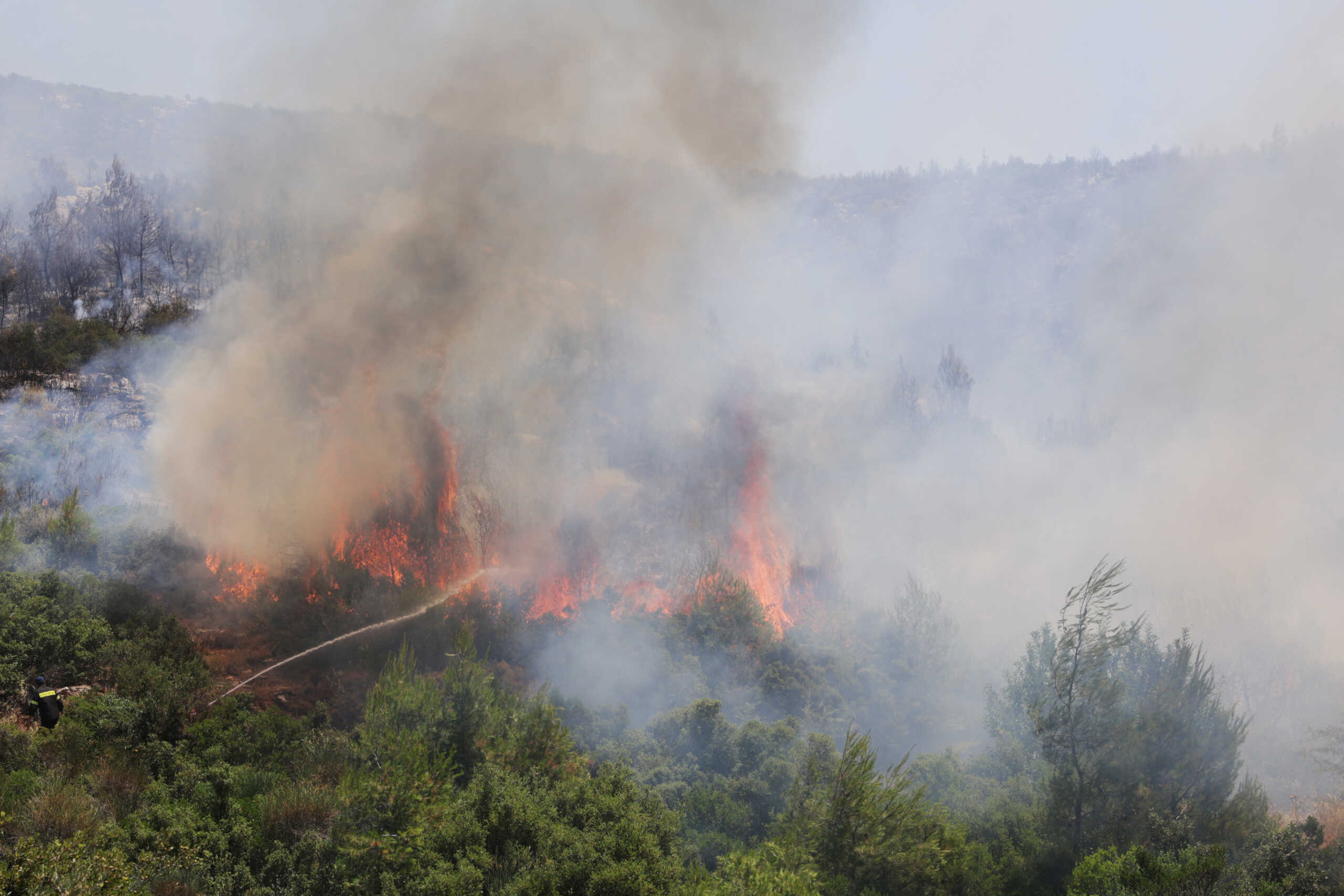 A firefighter tries to extinguish a wildfire burning near the village of Pournari, Greece, July 18, 2023. REUTERS