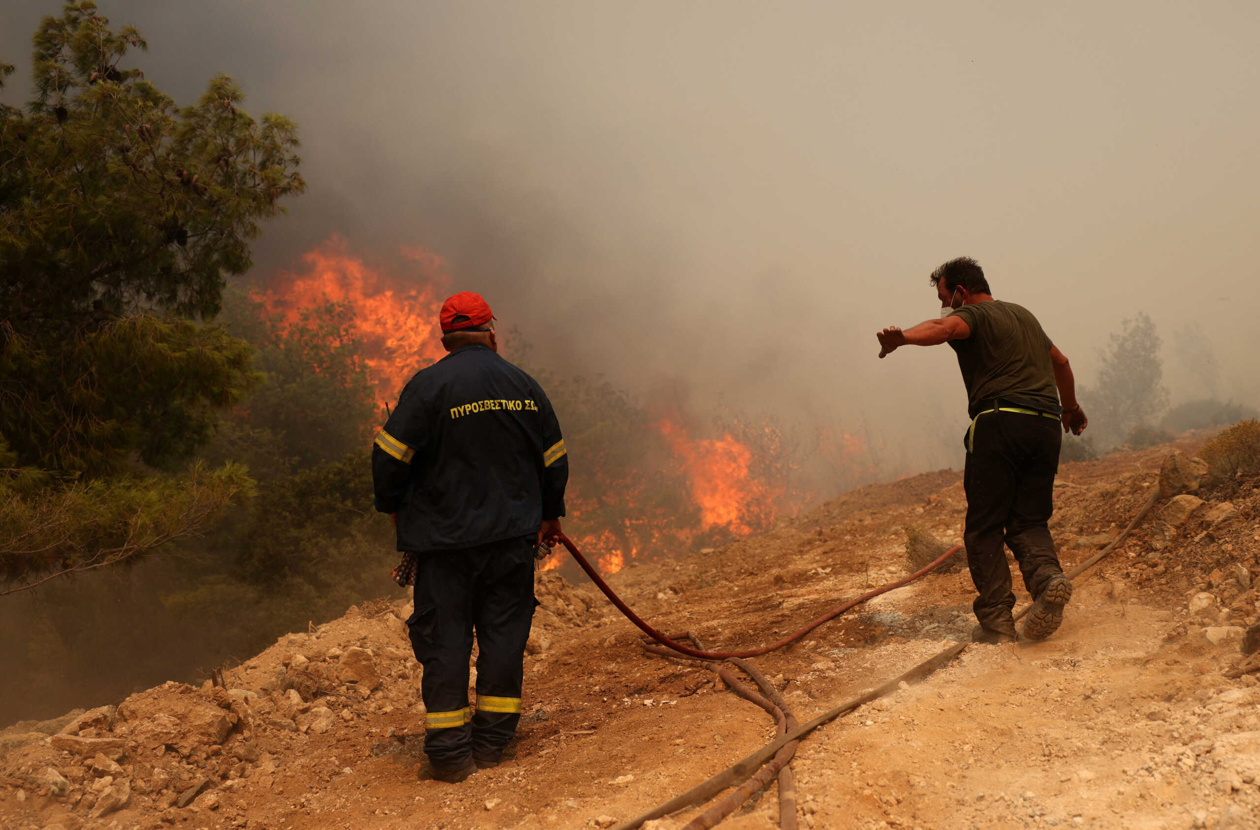 Firefighters try to extinguish a wildfire burning near the village of Kandyli, near Athens, Greece, July 19, 2023. REUTERS