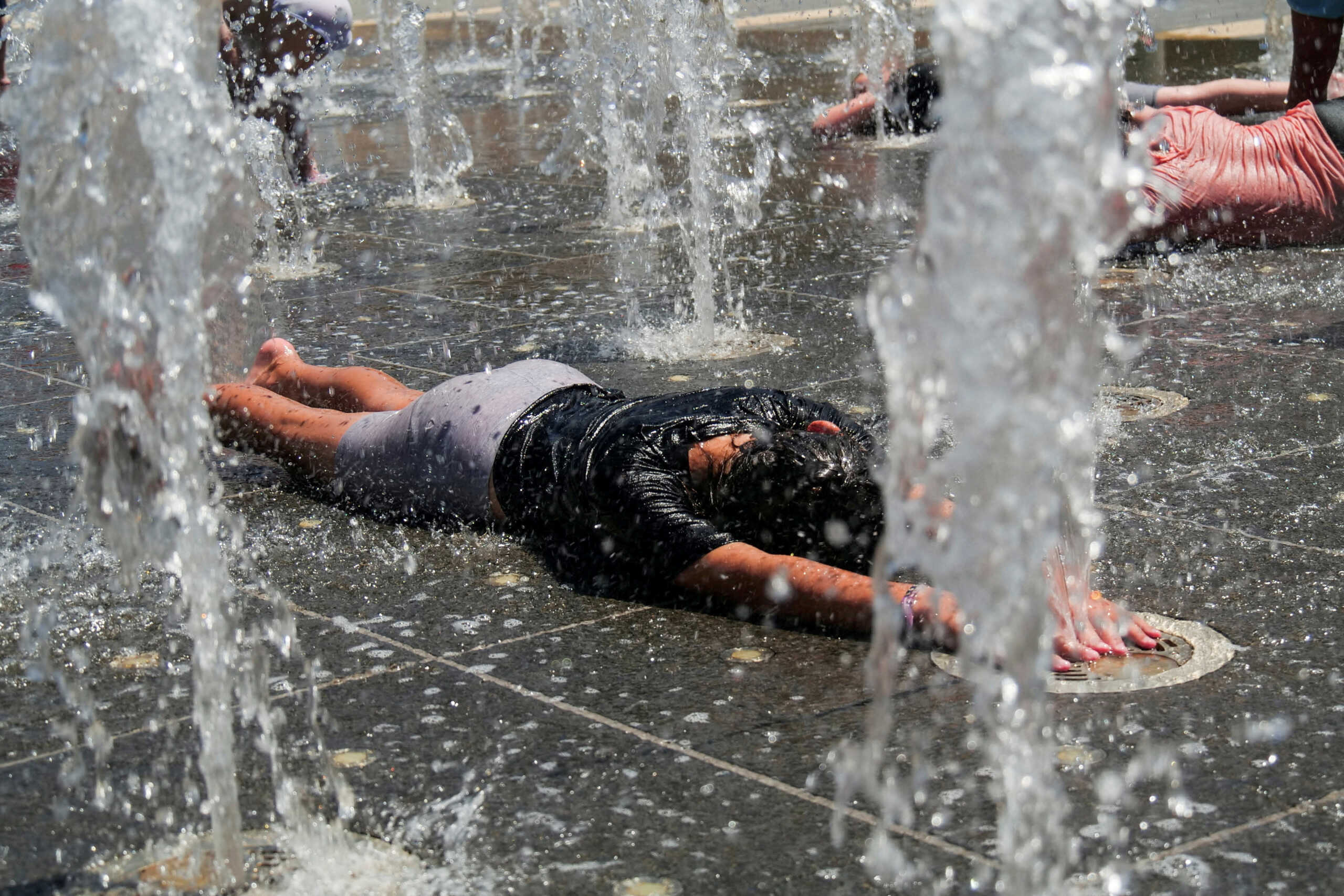 Children play in a water fountain during a heatwave, near the walls of Jerusalem's Old City, July 13, 2023. REUTERS