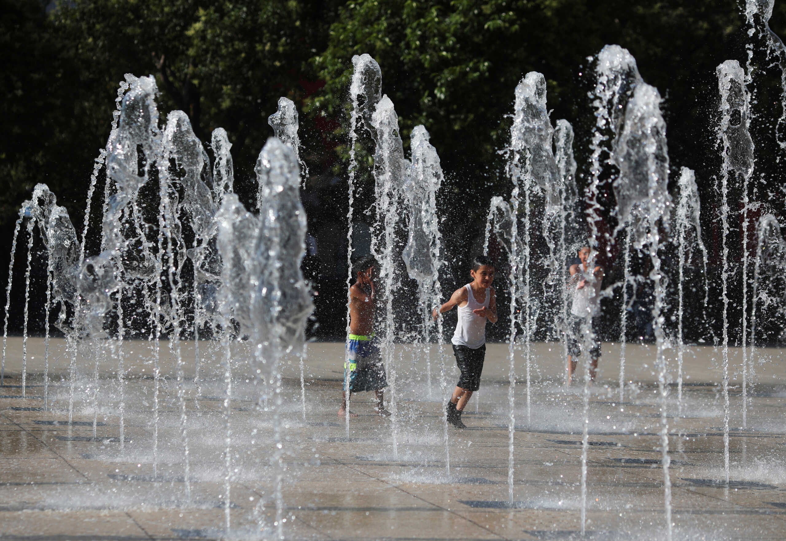 Children cool off during a period of high temperatures in fountains at the Monument to the Revolution in Mexico City, Mexico June 22, 2023. REUTERS